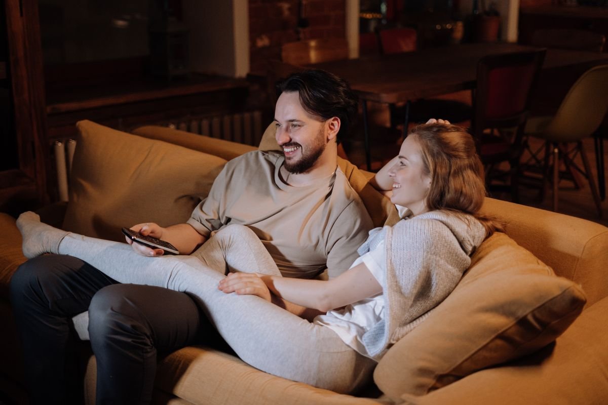 Couple relaxing together on a sofa in a cozy home in the evening