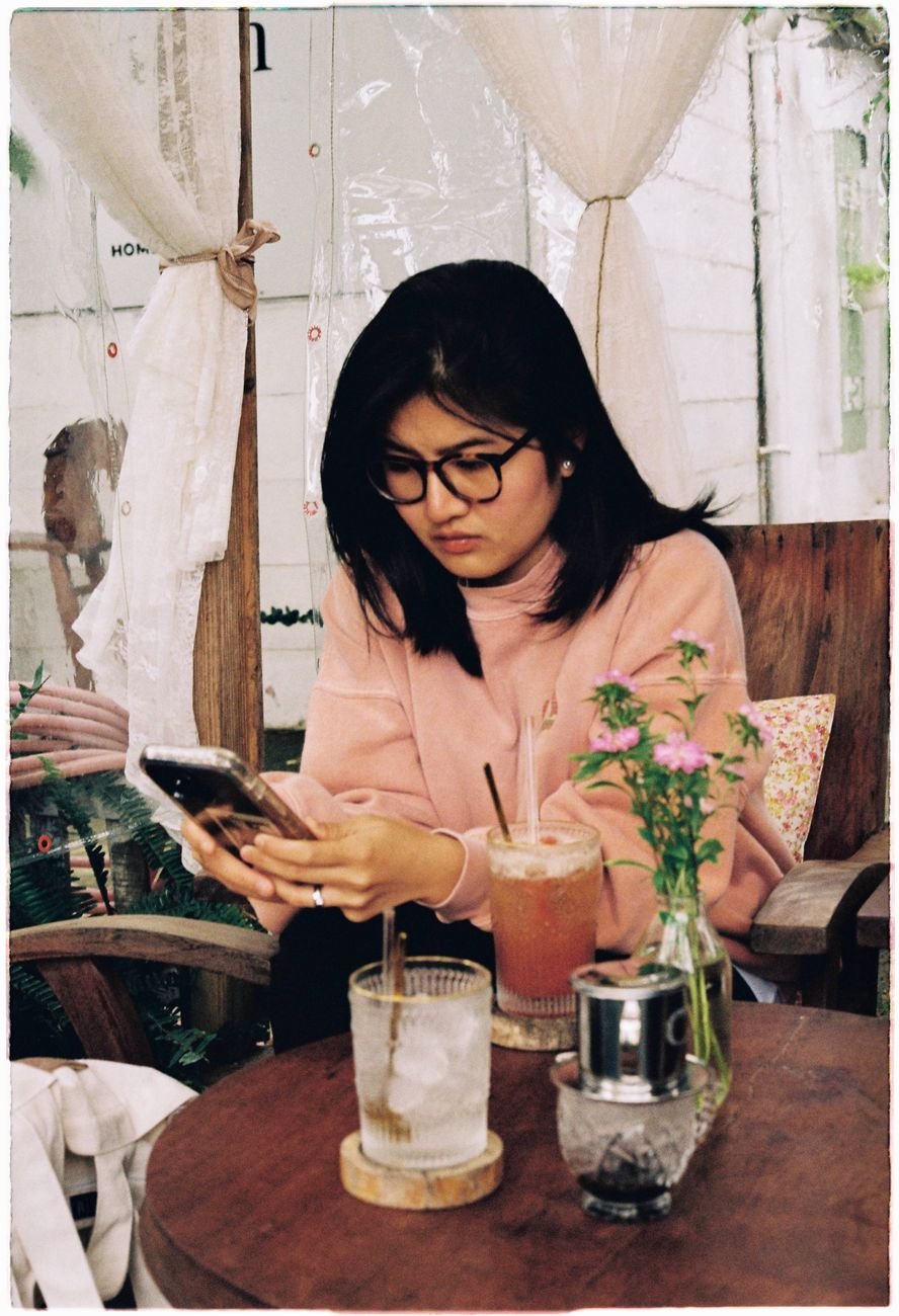 Woman comparing a dating app profile photo on her phone to the man in front of her