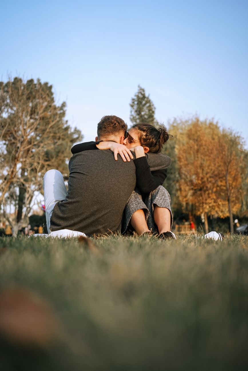 Couple sitting close on a park bench after a hard conversation about love