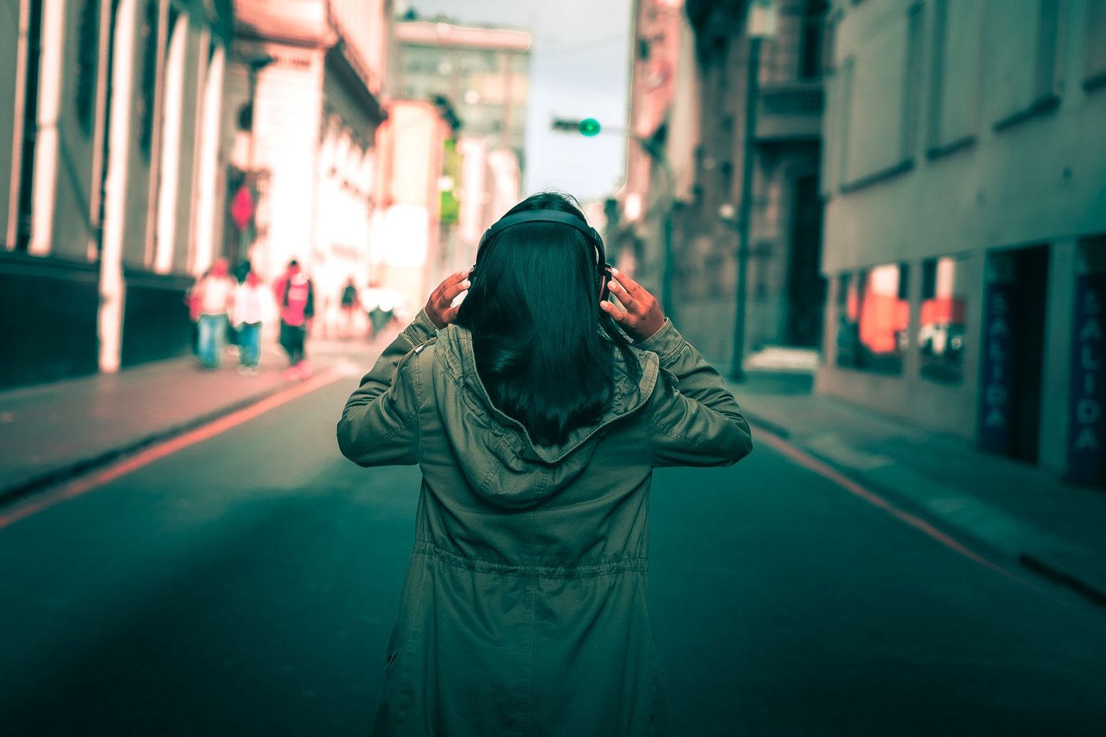 Woman walking outside with headphones instead of checking her ex Instagram