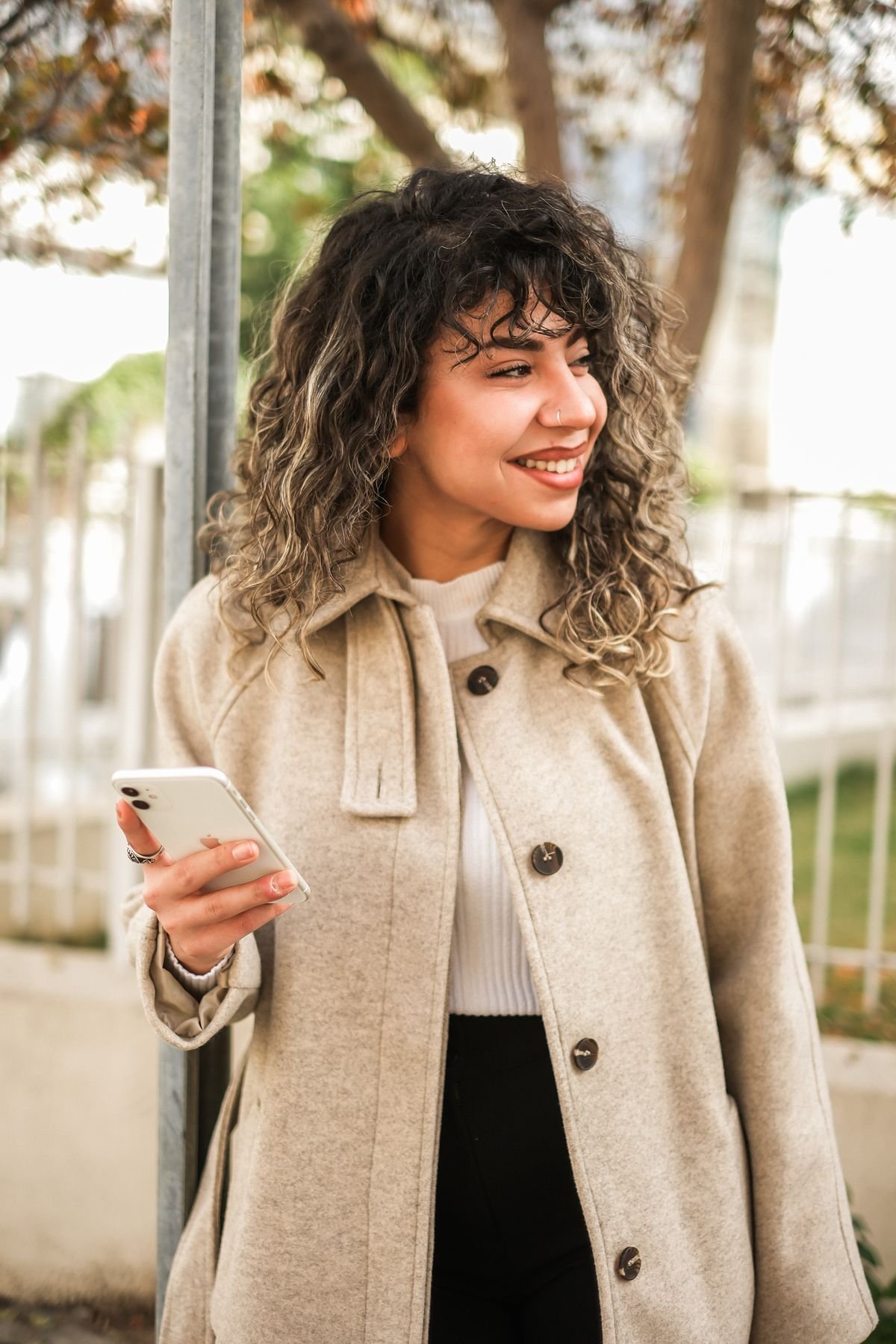 Woman smiling at her phone while staying positive in a long distance relationship