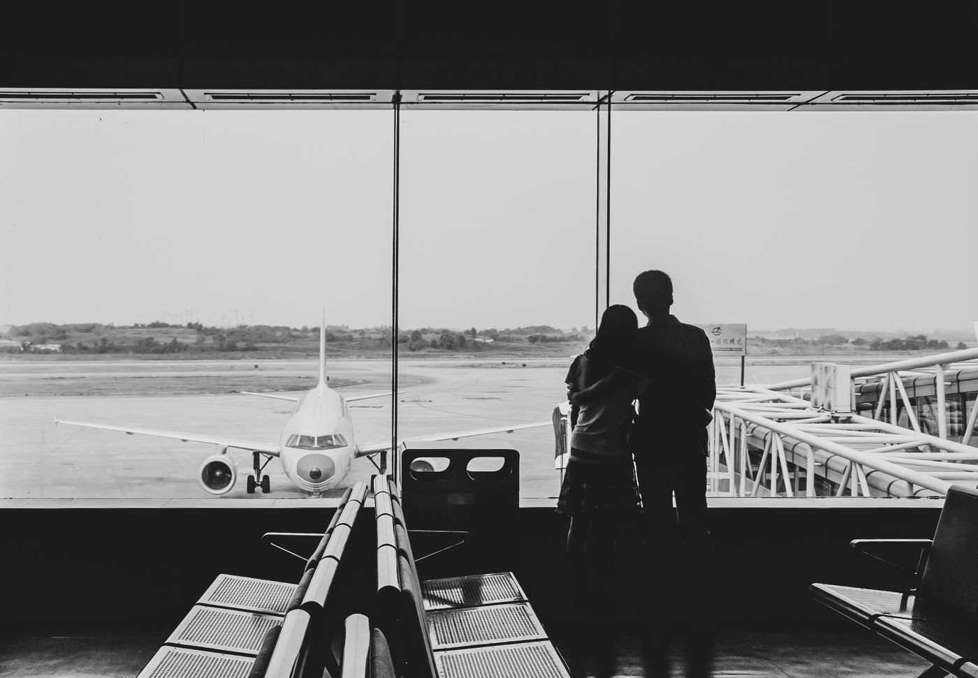 Couple hugging at an airport terminal before a long distance goodbye