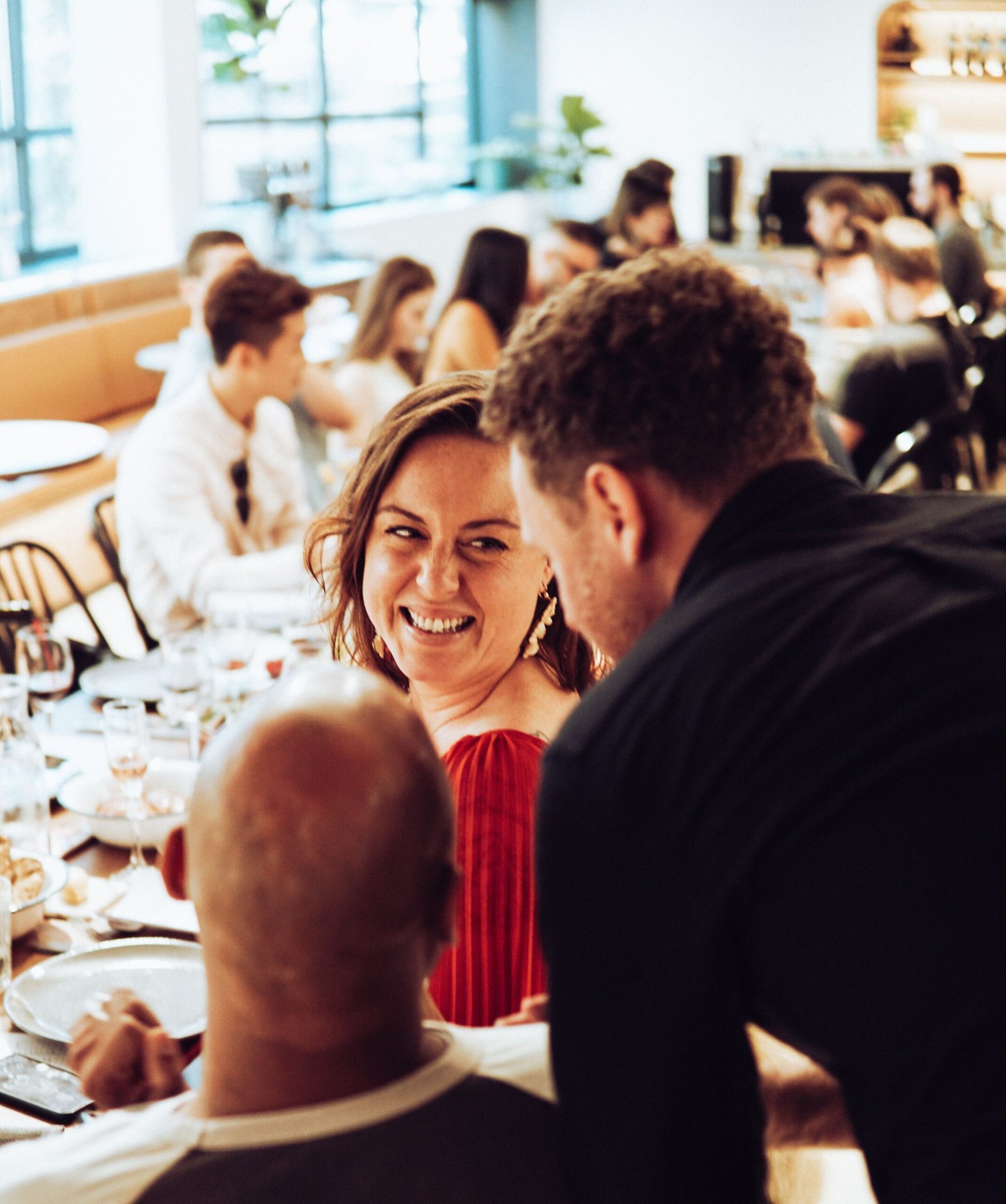 Friends raising glasses at a restaurant dinner table where news gets shared