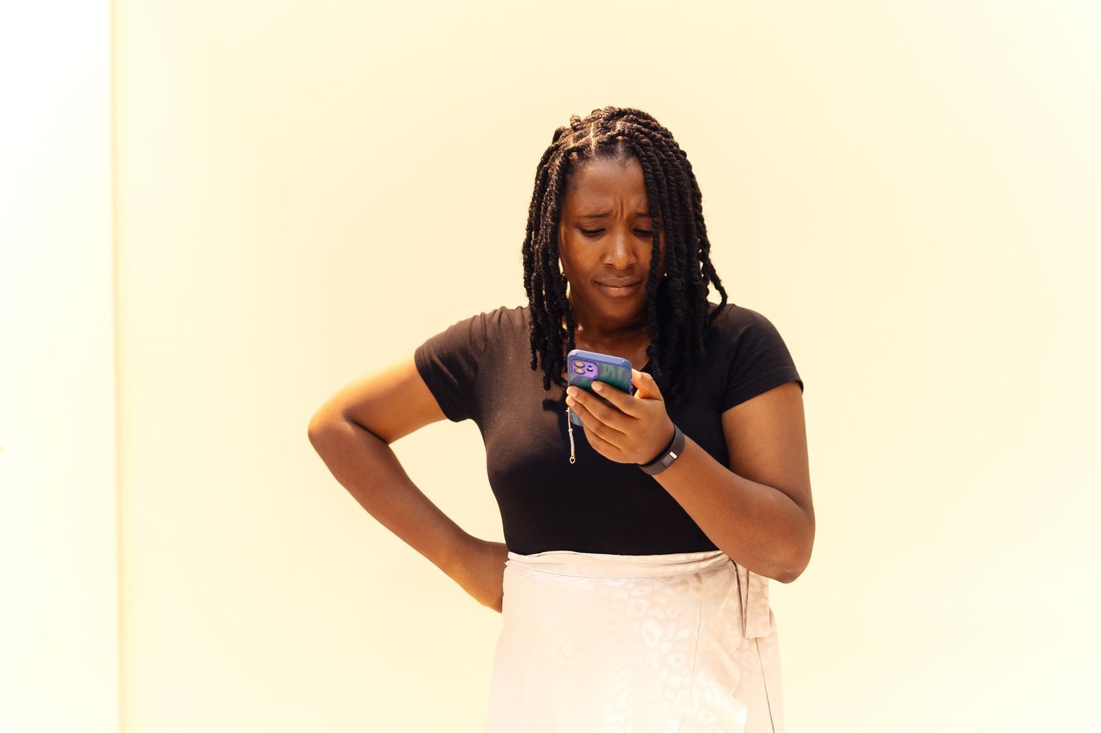 Woman reading a text message with a worried expression after a long distance misunderstanding