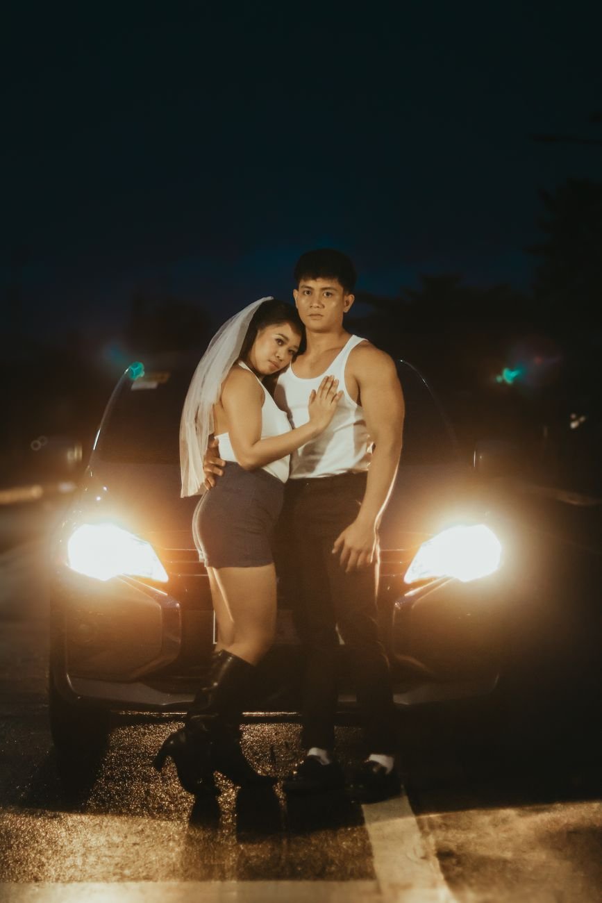 Couple sitting close together in a car at night