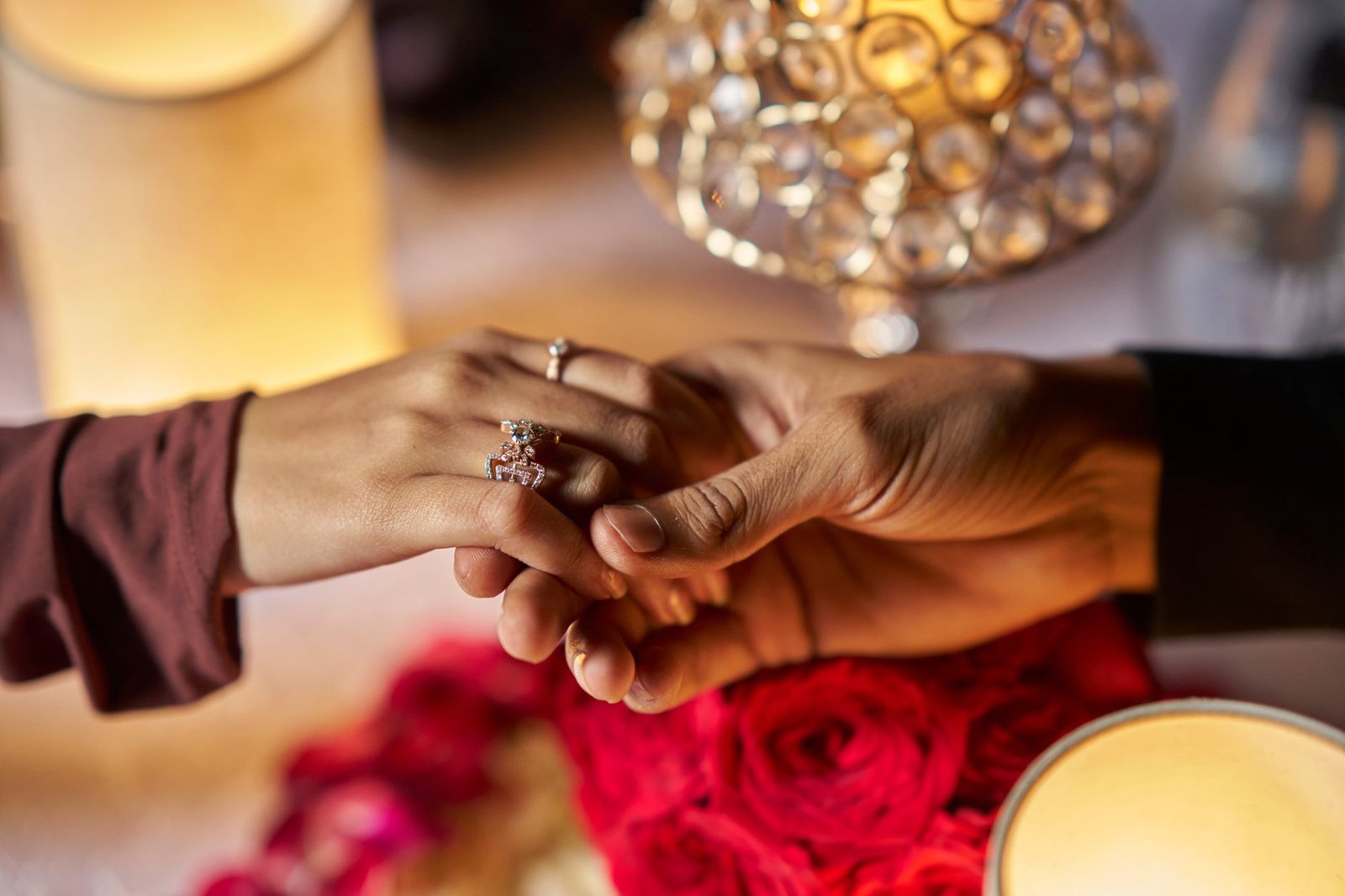Thin gold engagement ring with a small oval stone on a womans hand