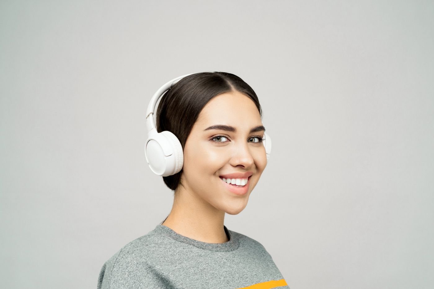 Woman in white headphones listening closely during a long distance phone call