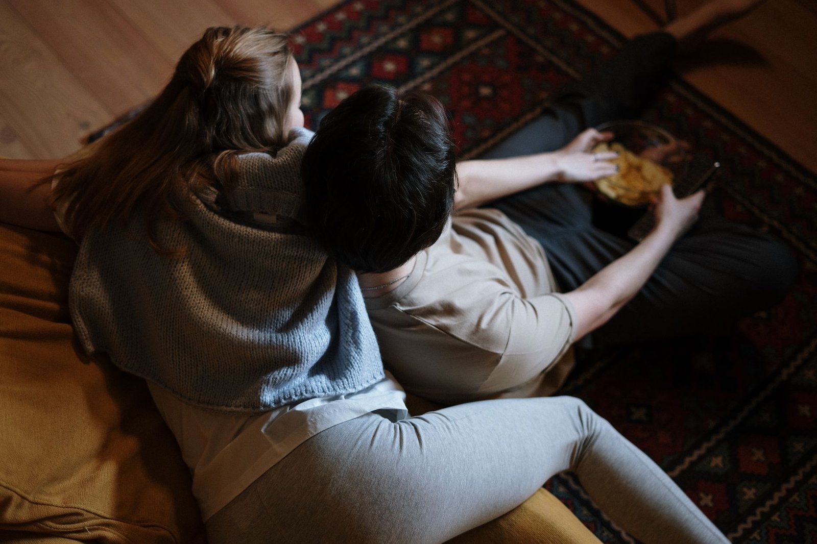Couple sitting quietly on a couch at home after the honeymoon phase ends