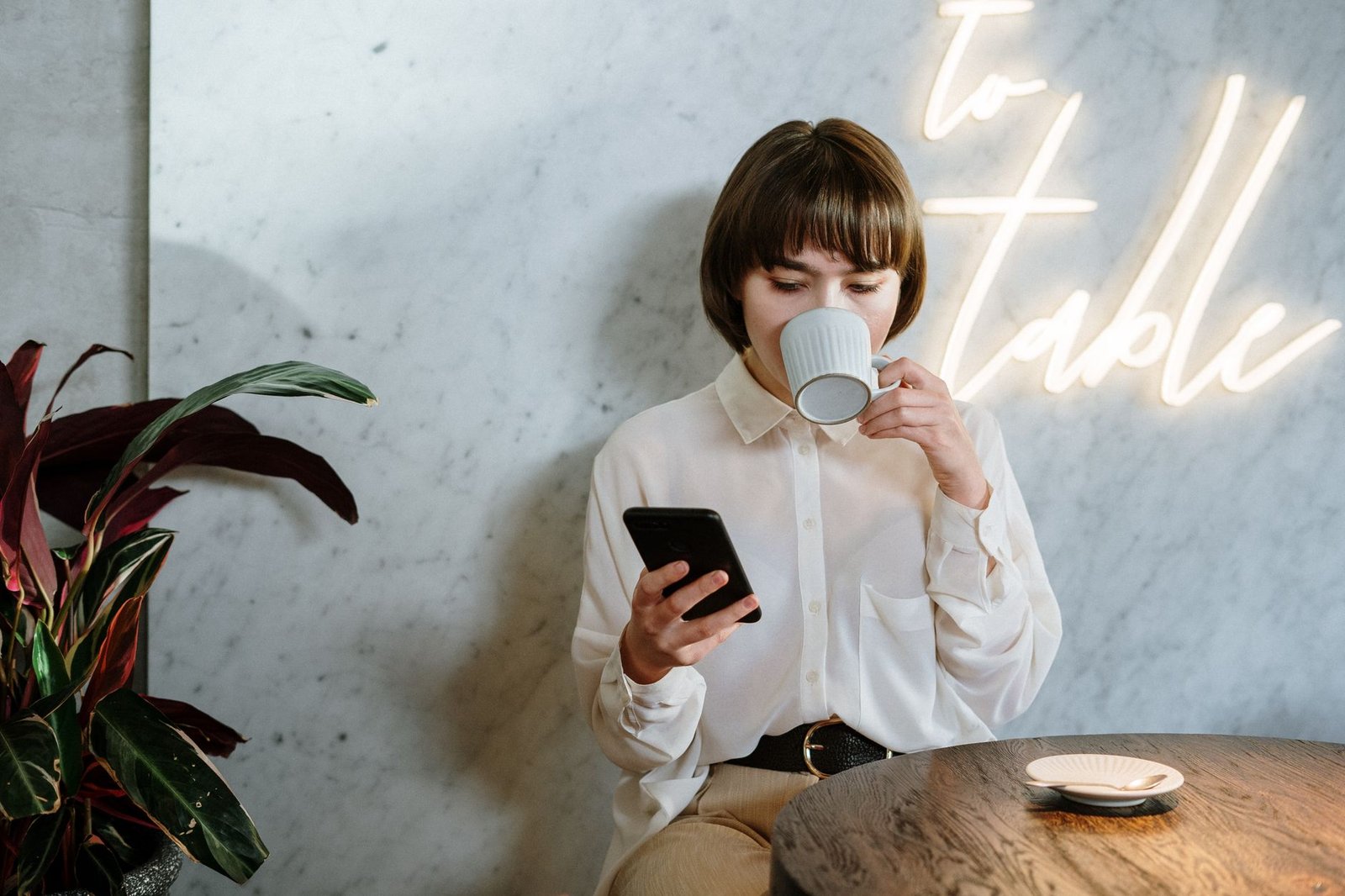 Woman in a cafe looking at two weeks of texting history on her phone