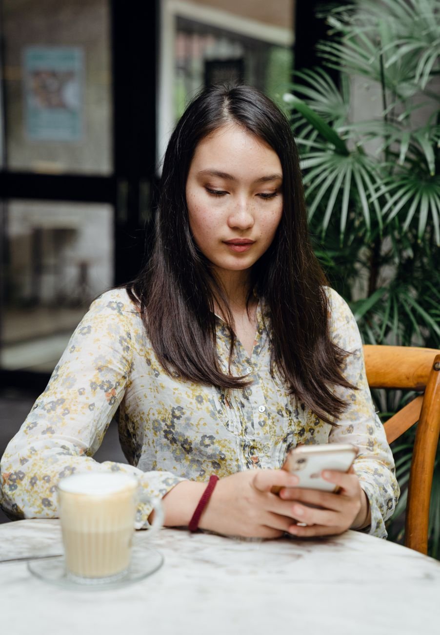 Woman on a couch scrolling back through a long text thread counting his messages