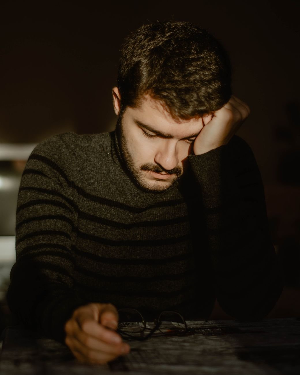 Man sitting alone looking tired after a disappointing day at work