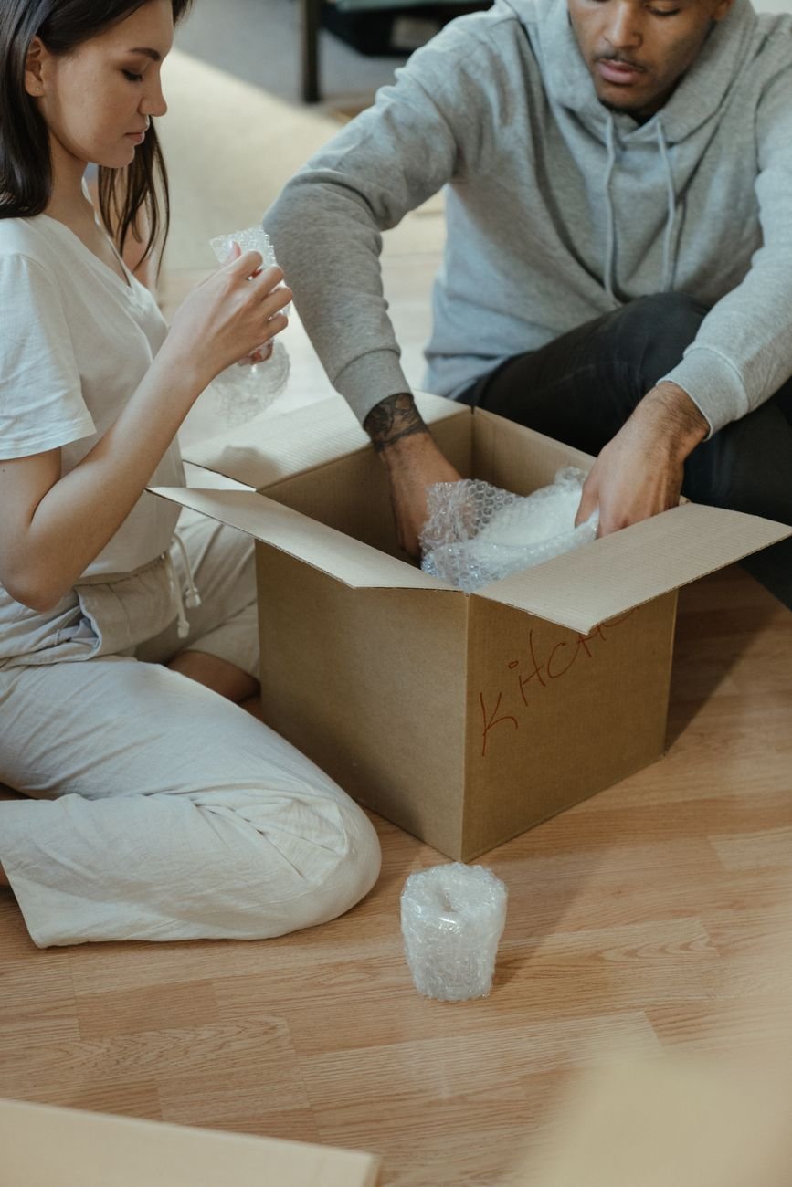 Couple unpacking kitchen items into their new shared home