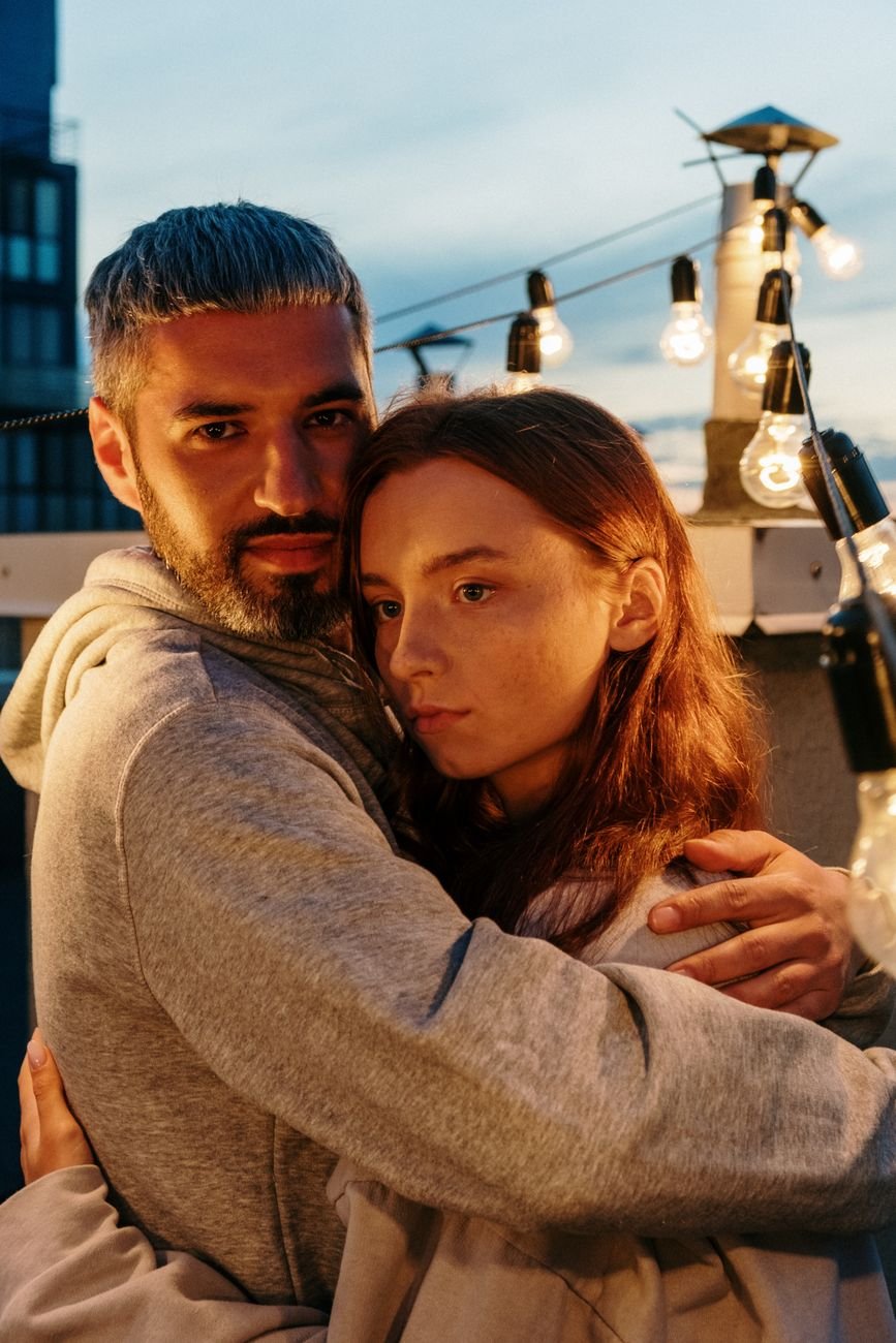 Couple hugging under string lights months after saying I love you