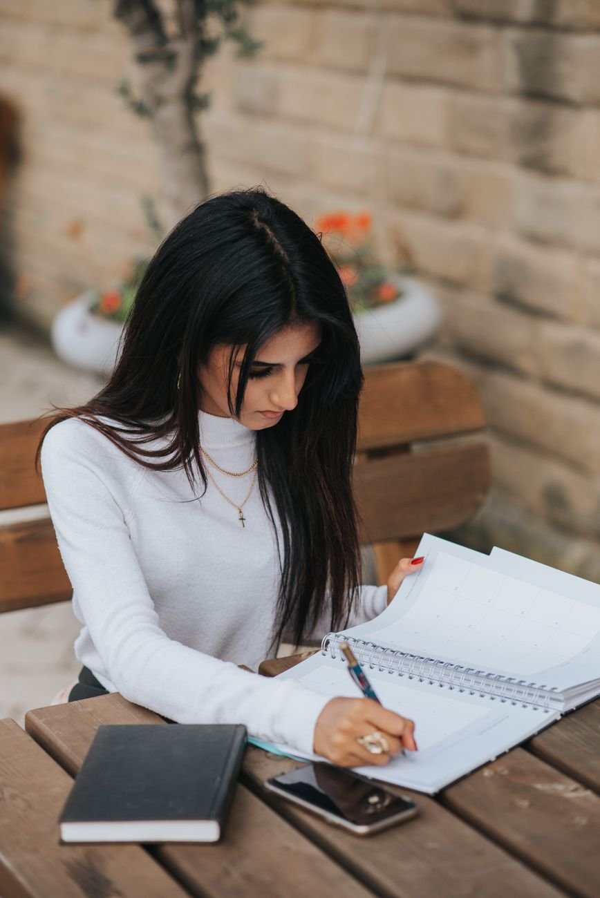 Woman writing down one clear request in a notepad before a hard talk with her boyfriend