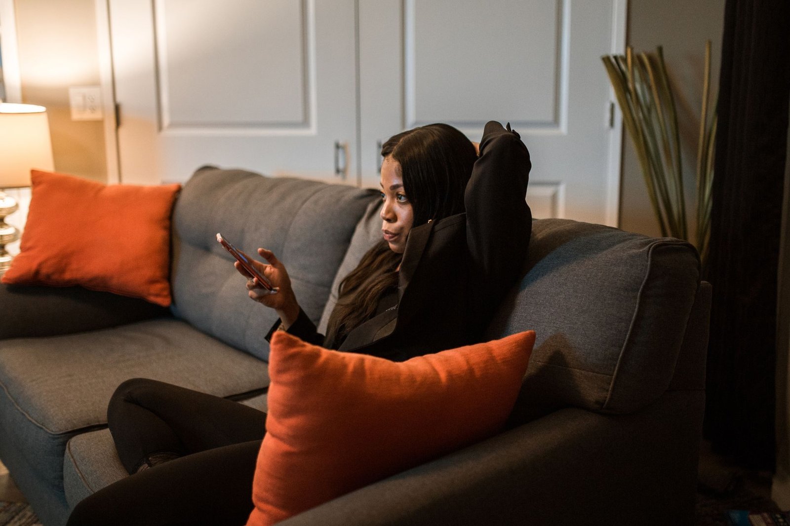 Woman relaxing on the couch at night sending an evening check-in text