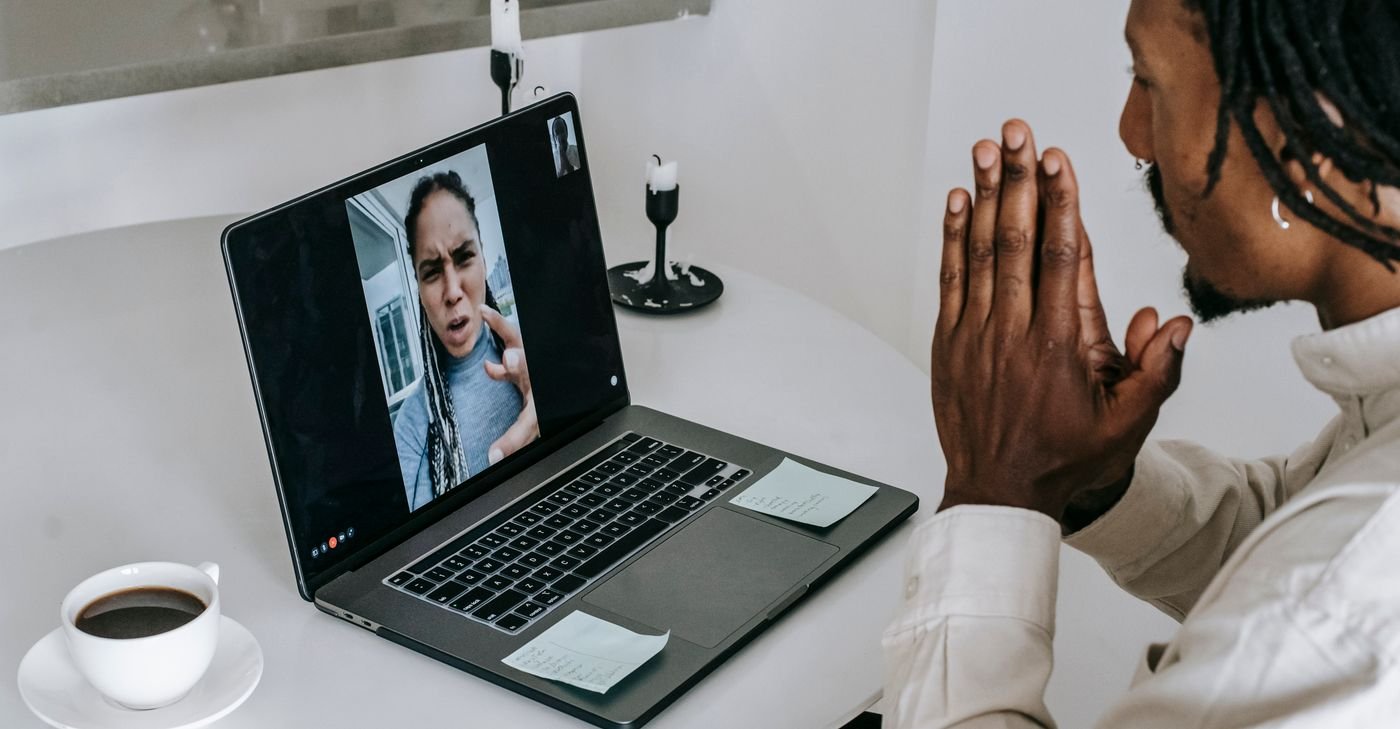 Couple on a laptop video call having a tense miscommunication in a long distance relationship