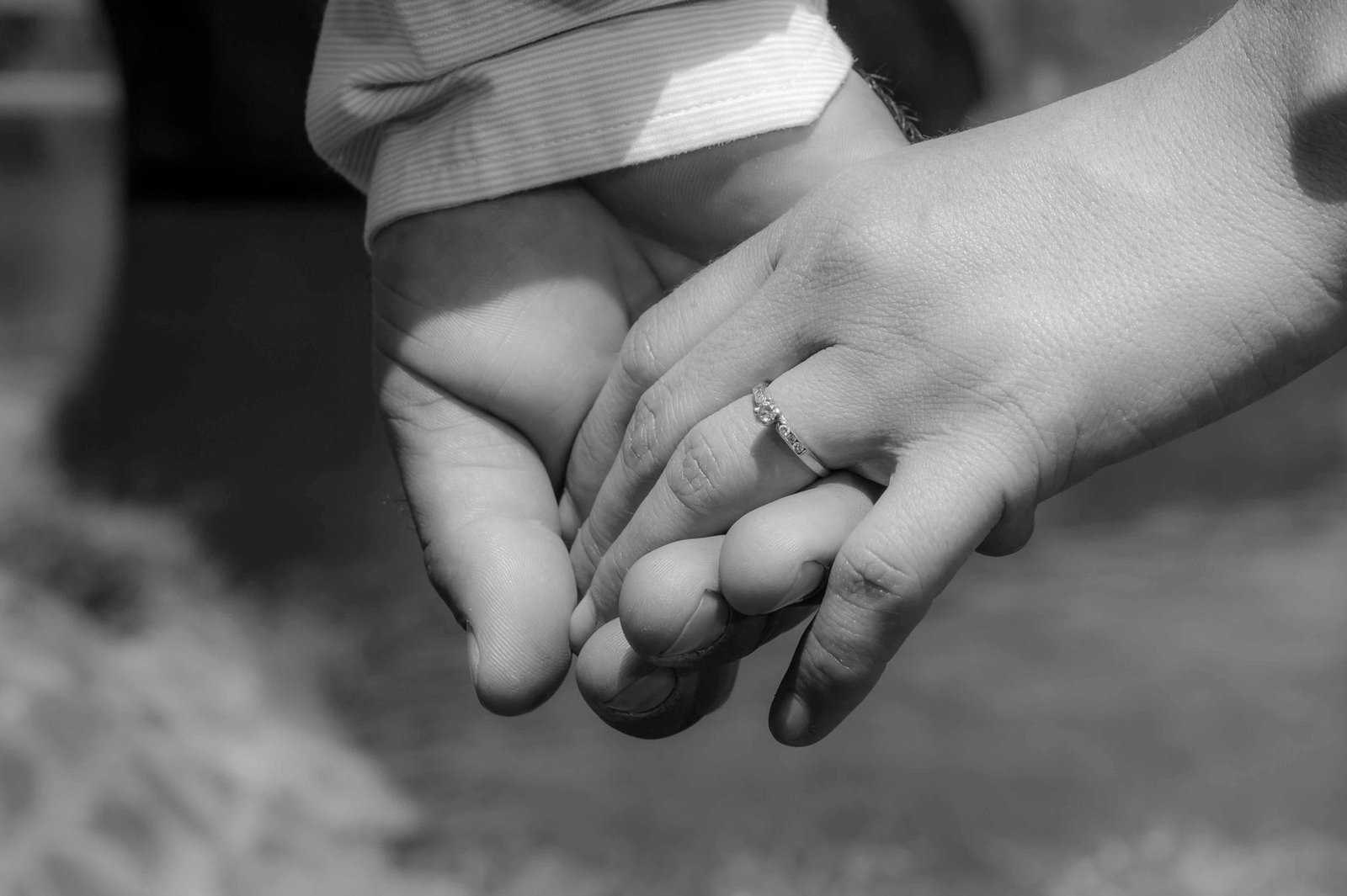 Close up of an engaged couple holding hands with an engagement ring during a long engagement