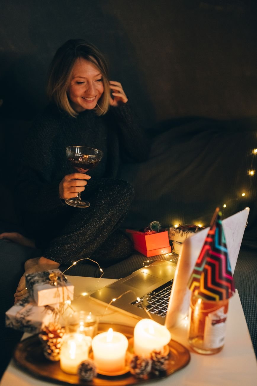 Woman wiping her eyes while sitting on the floor of her apartment at night