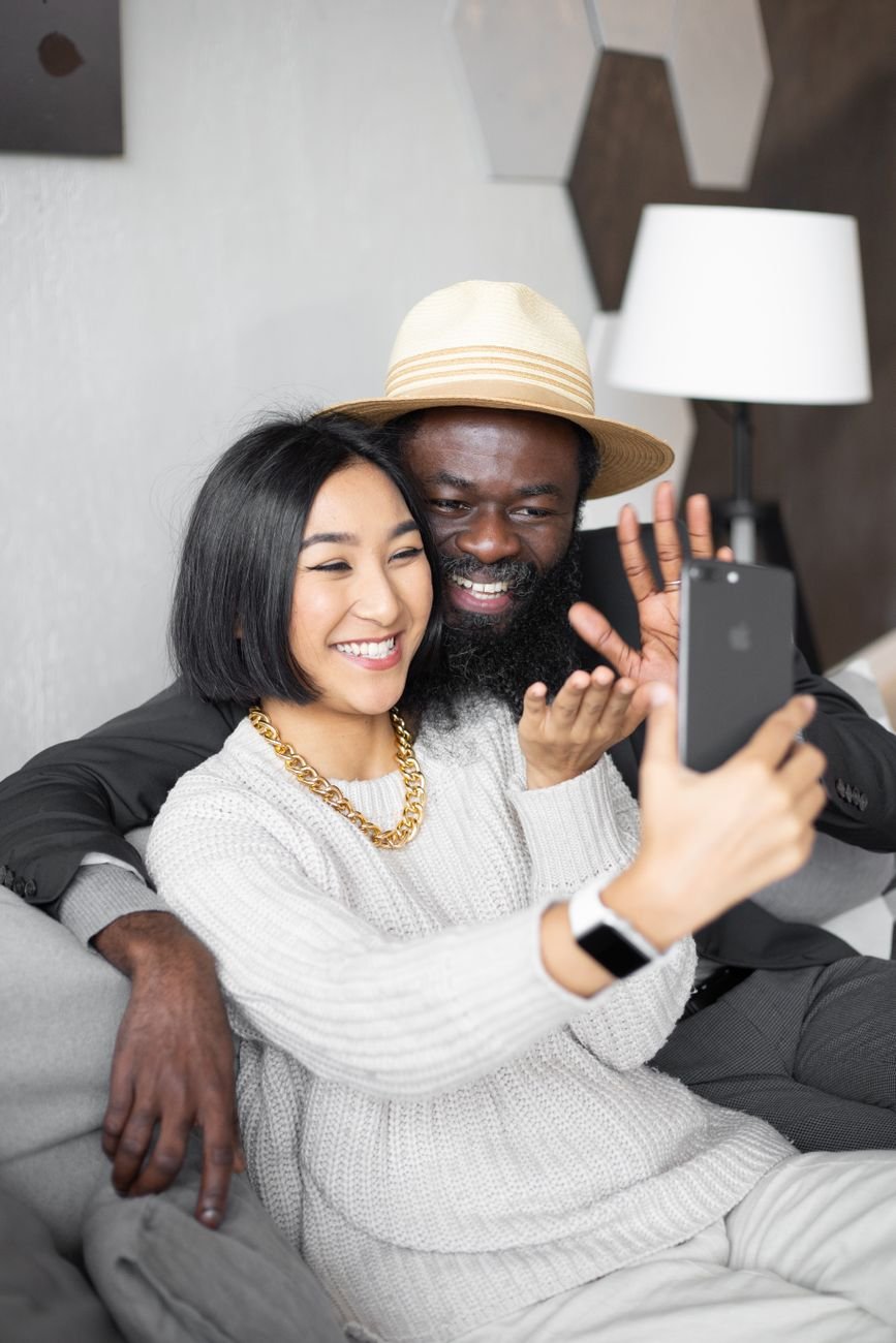 Woman video calling her partner on her phone from the couch