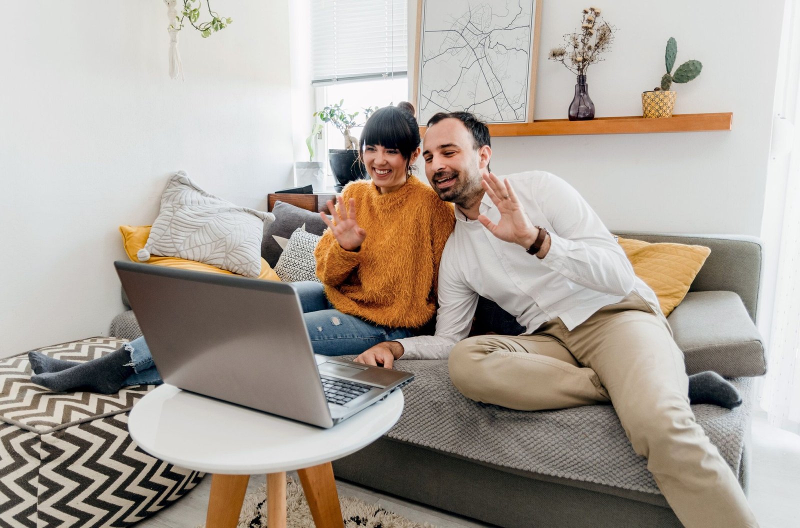 Couple on a couch smiling during a video call