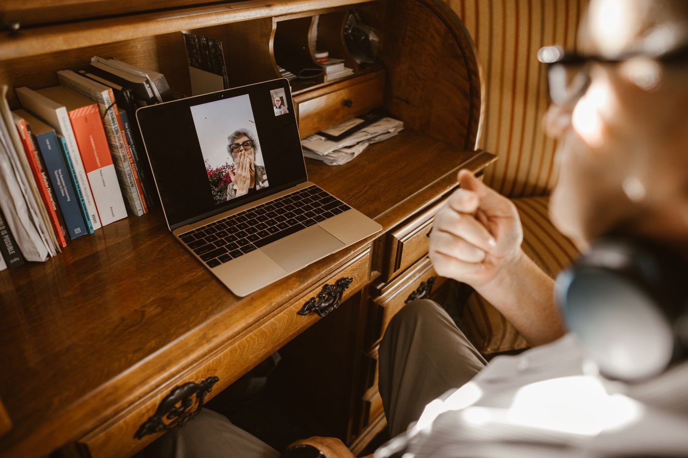Woman on a laptop video call at a wooden desk during a scheduled long distance date night