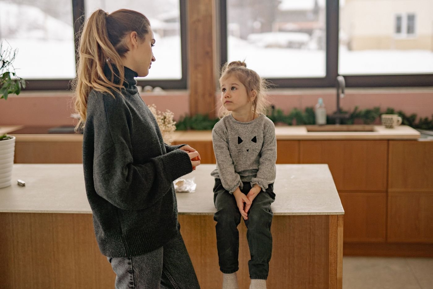 Mother and daughter in a warm kitchen having an honest conversation