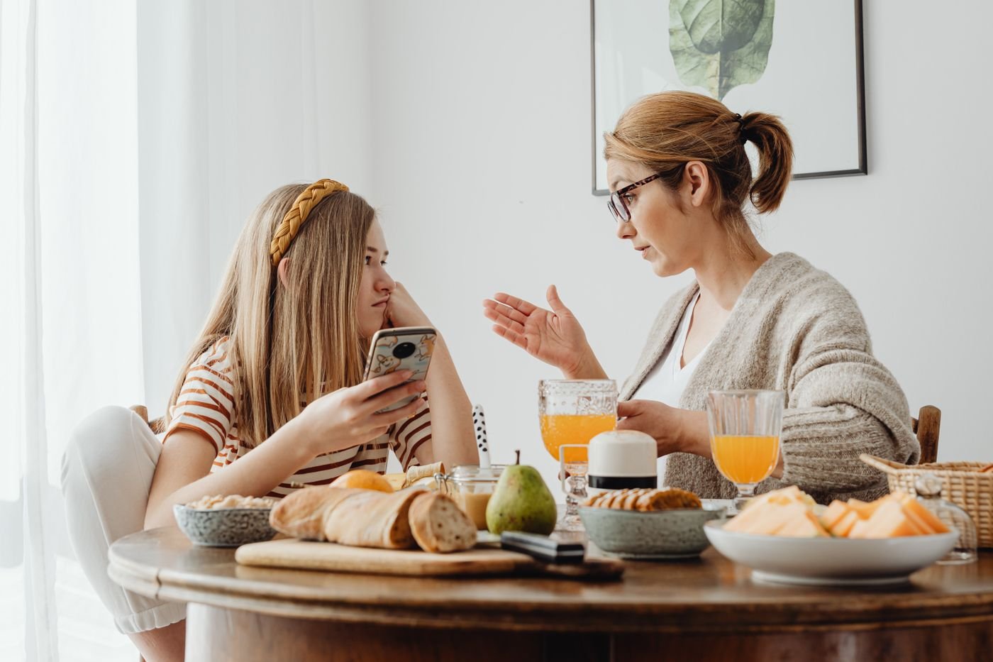 Mother and daughter talking over breakfast about her long distance relationship