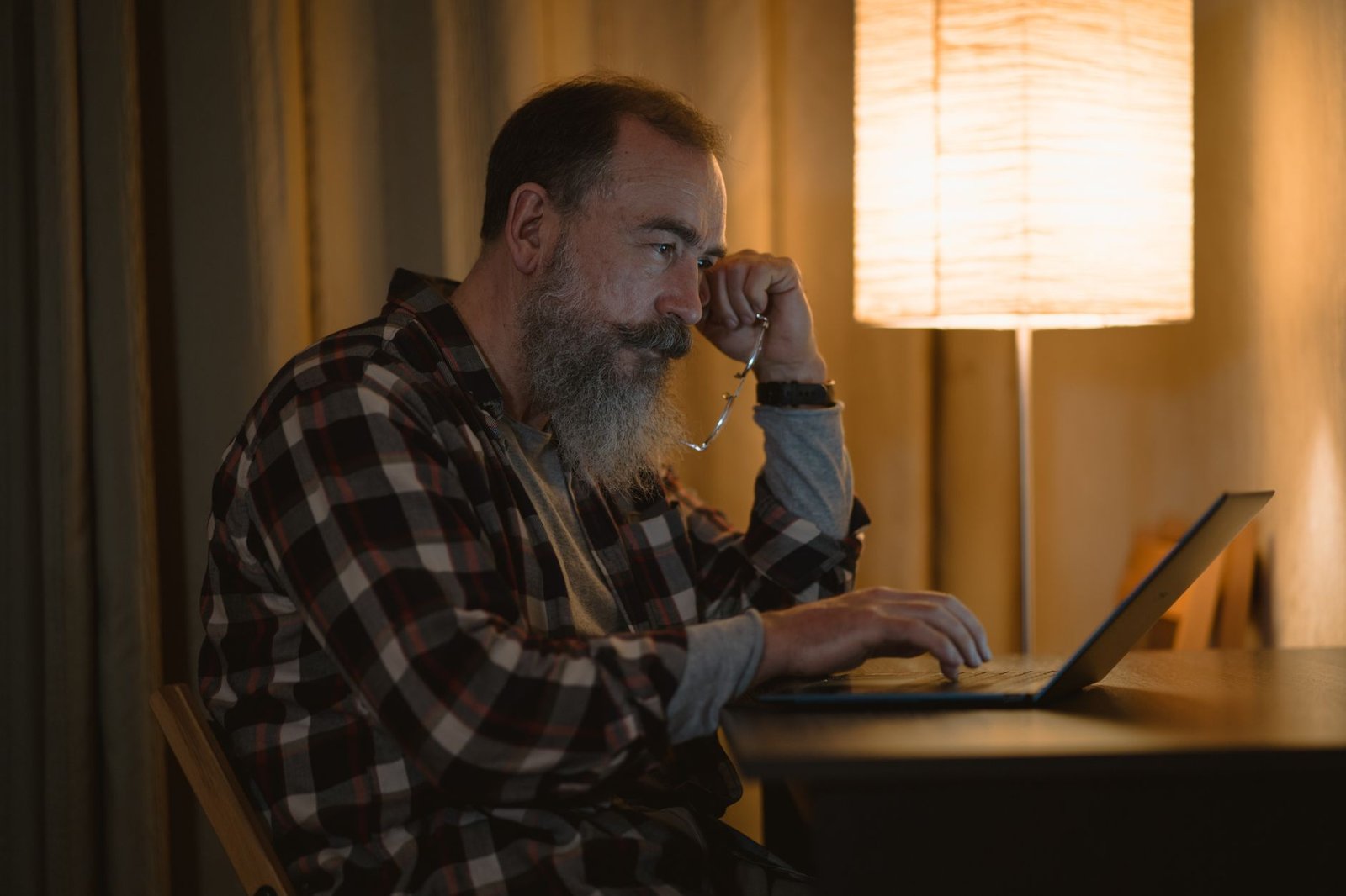 Man working late under warm lamp light at his desk