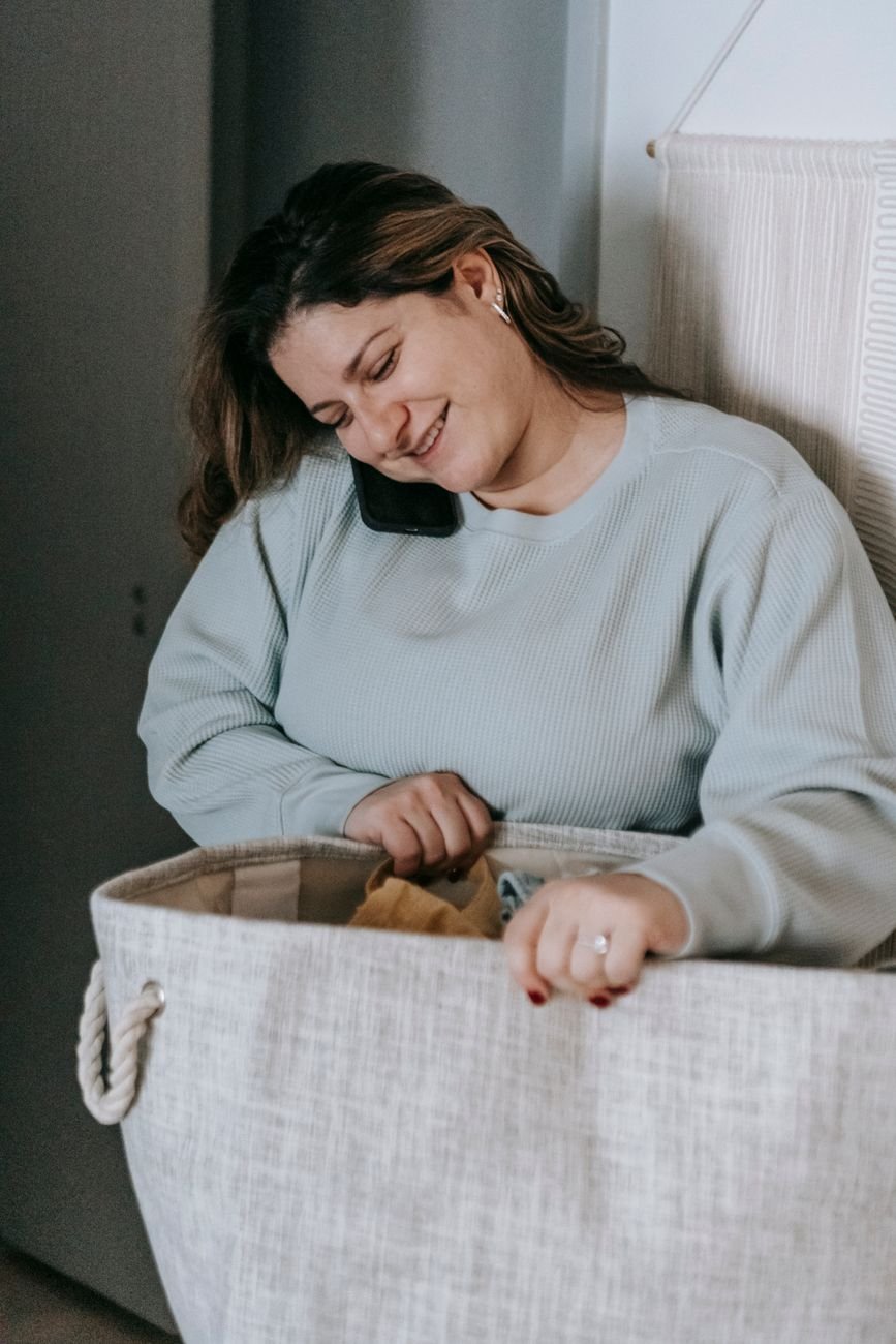 Woman doing laundry while on a phone call with her long distance partner
