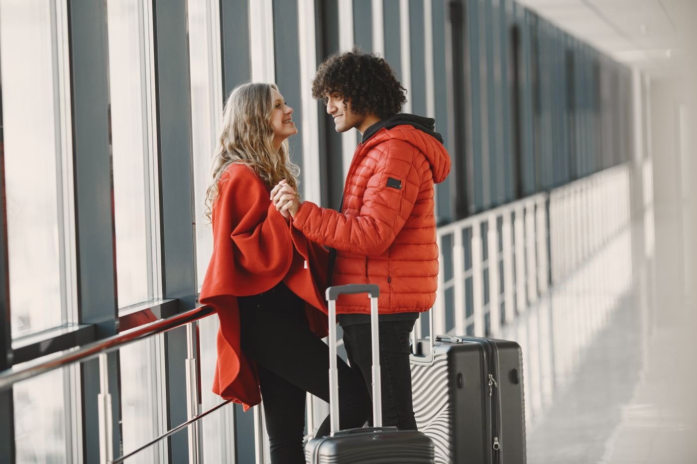 Happy couple with luggage in an airport terminal reuniting after months apart