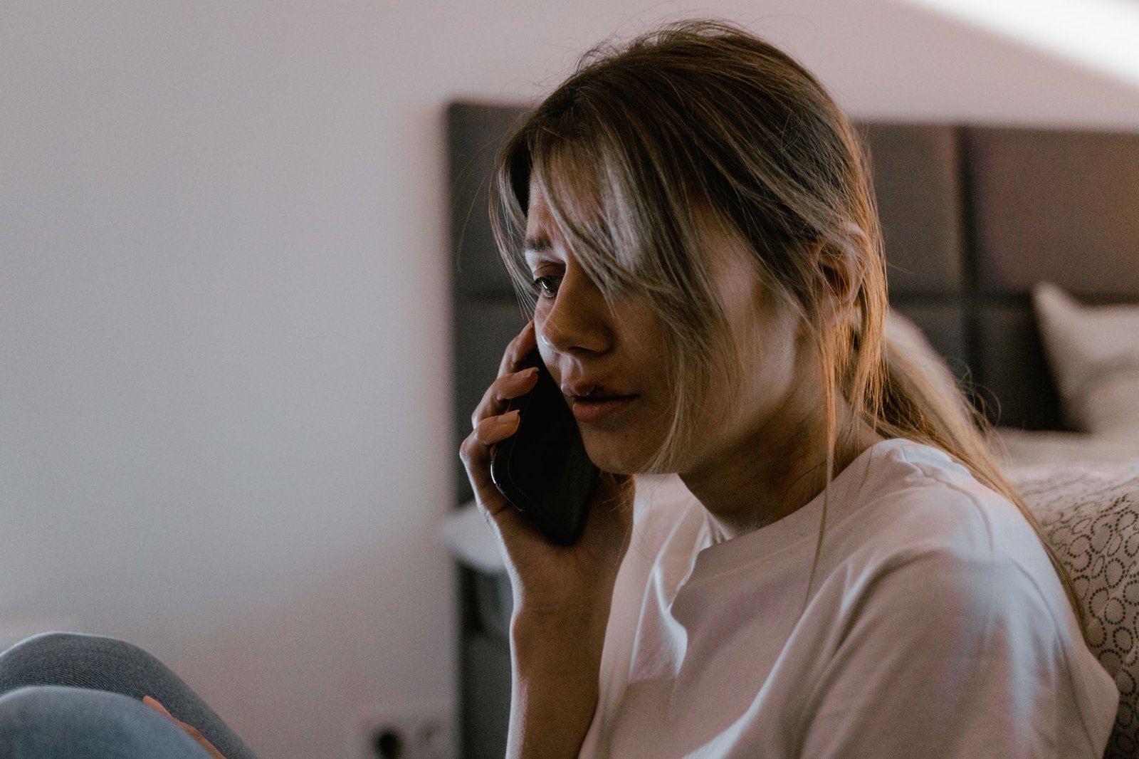 Sad woman looking down at her phone