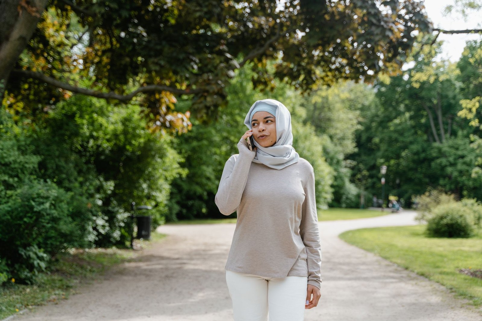 Woman walking outdoors while talking on the phone with her long distance partner