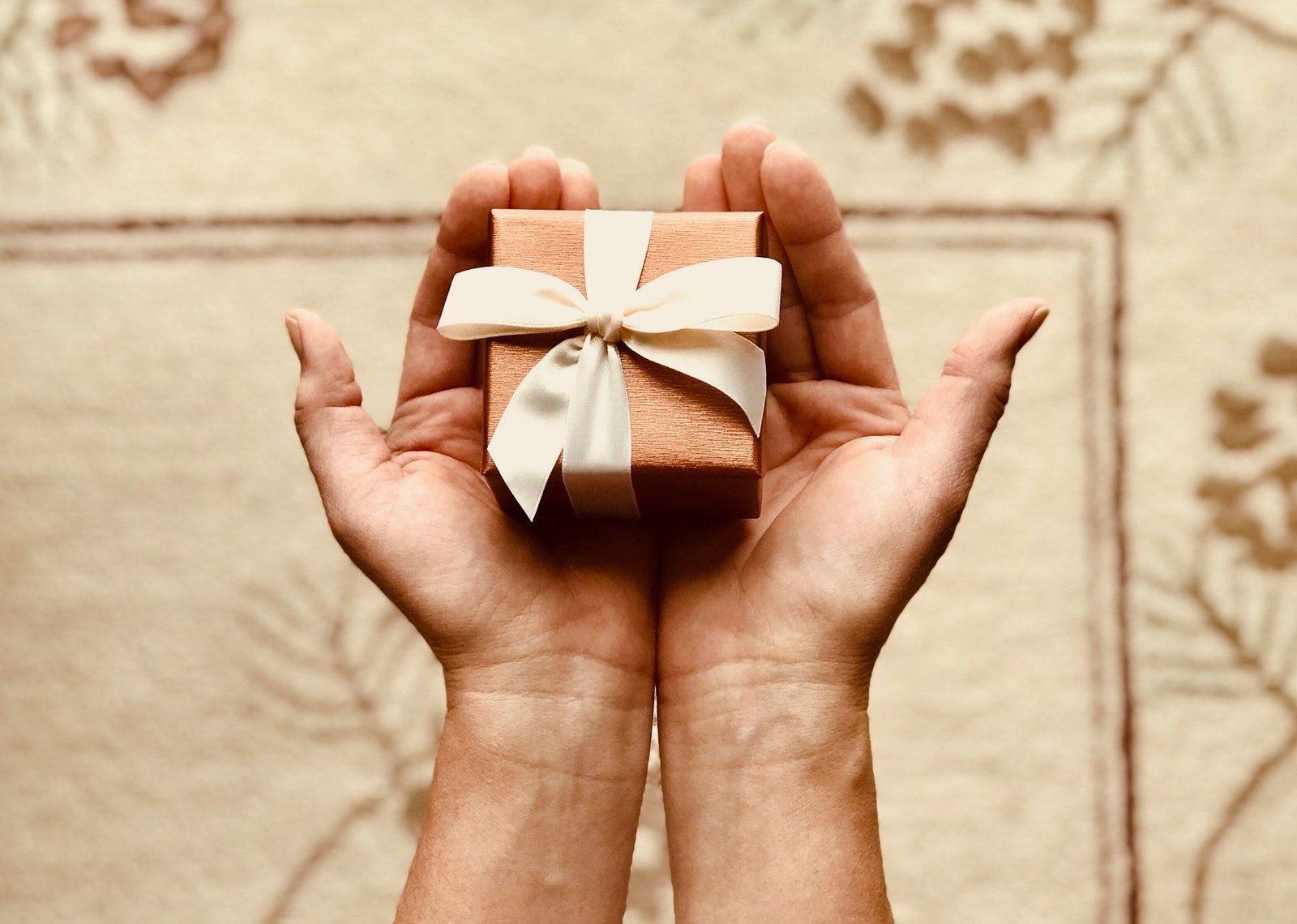 Small wrapped gift being handed over as a love language of receiving gifts