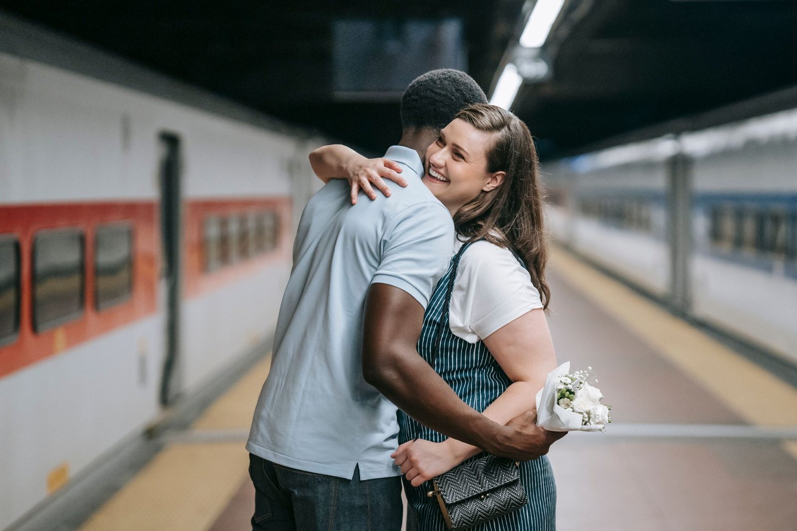 Couple hugging joyfully on a train platform