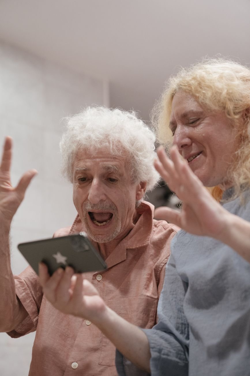 Older couple laughing during a video call on a smartphone at home