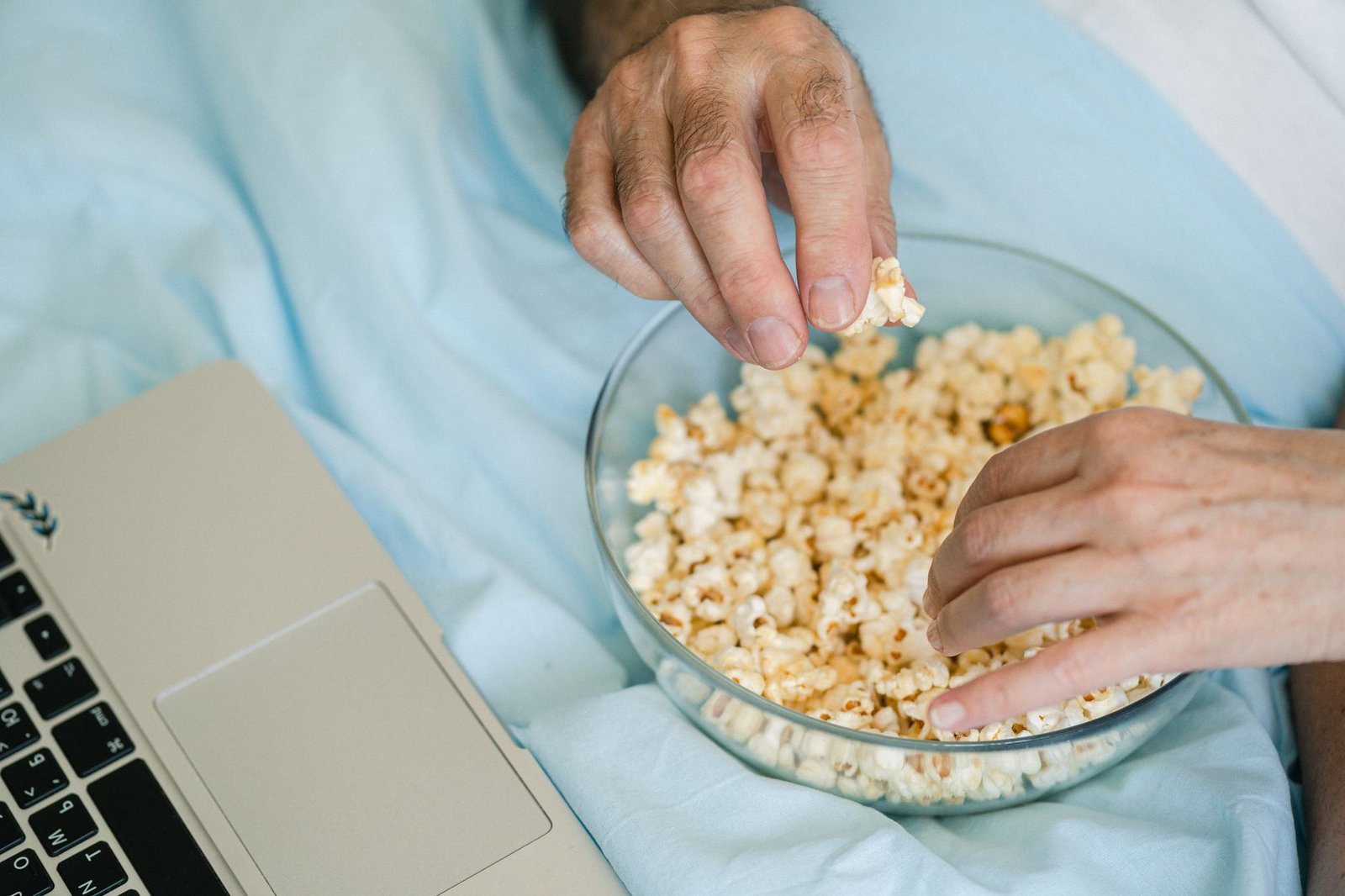 Woman watching a movie on her laptop during a long distance virtual hangout