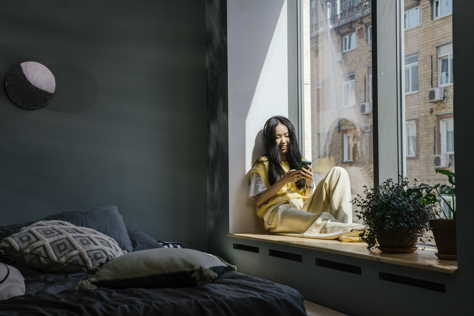 woman reading a message from her long distance partner by a window