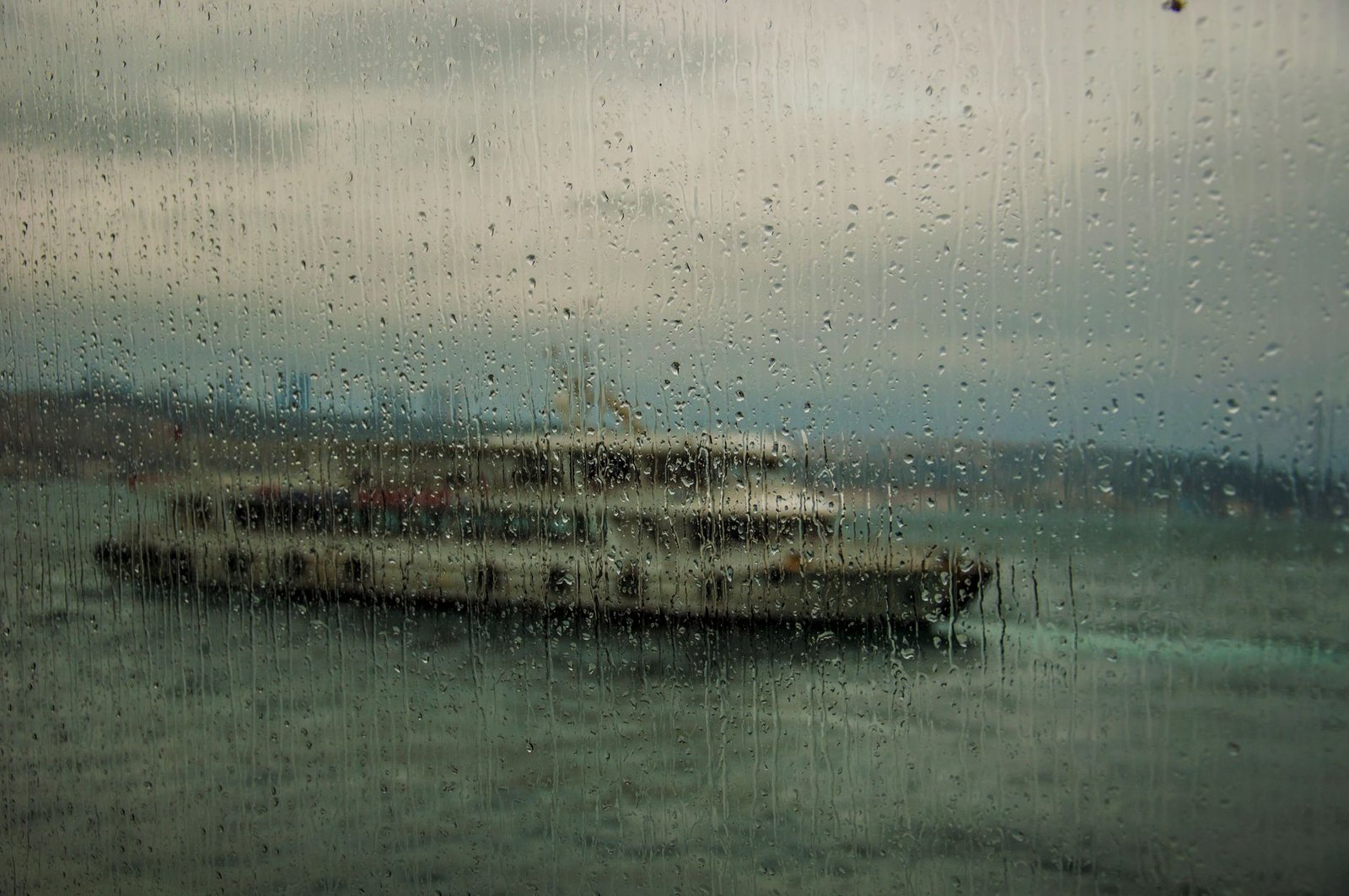 Woman looking out a rainy ferry window thinking about a move closer to his parents
