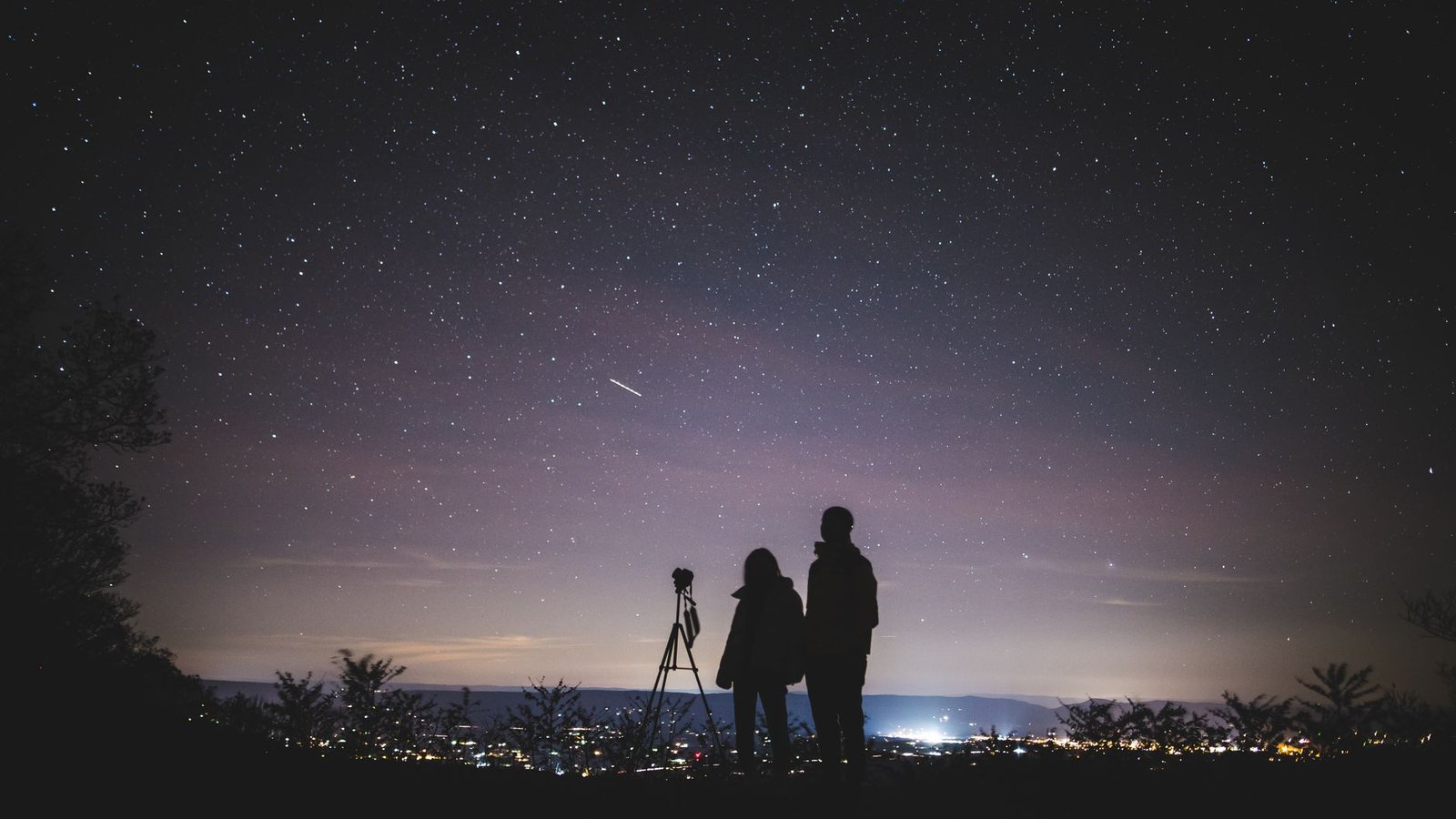 Couple lying on a blanket stargazing at a state park after a planned surprise