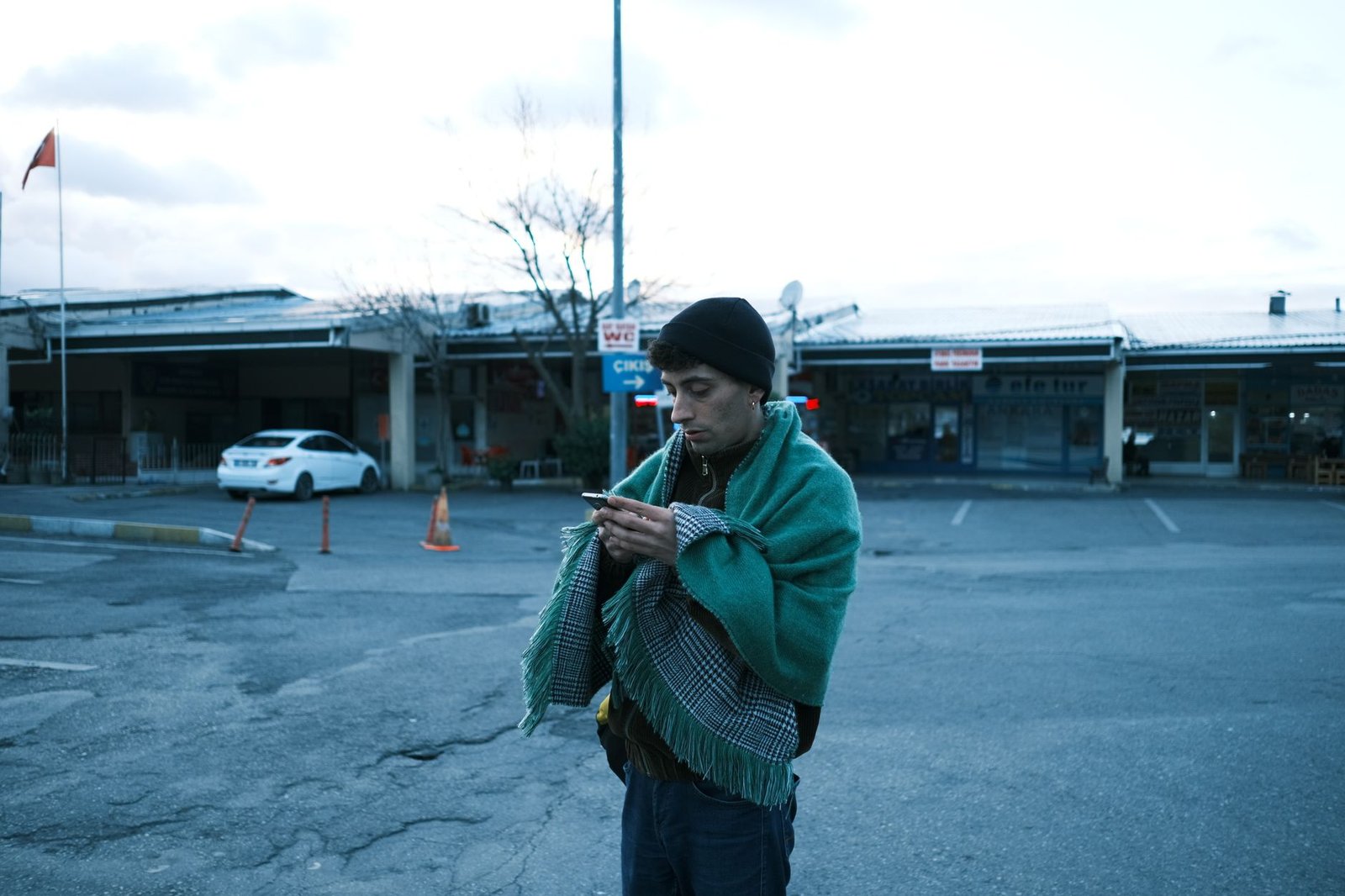 Woman reading a missed call text on her phone in a parking lot