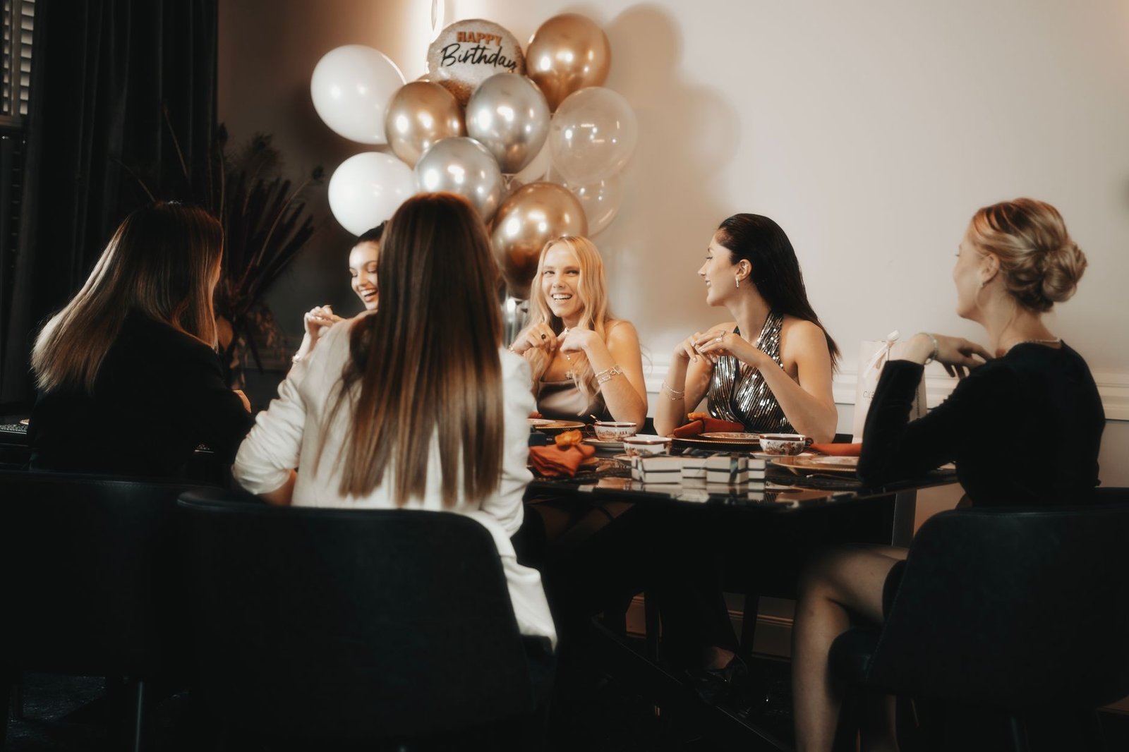 Friends gathered around a birthday dinner table with place cards