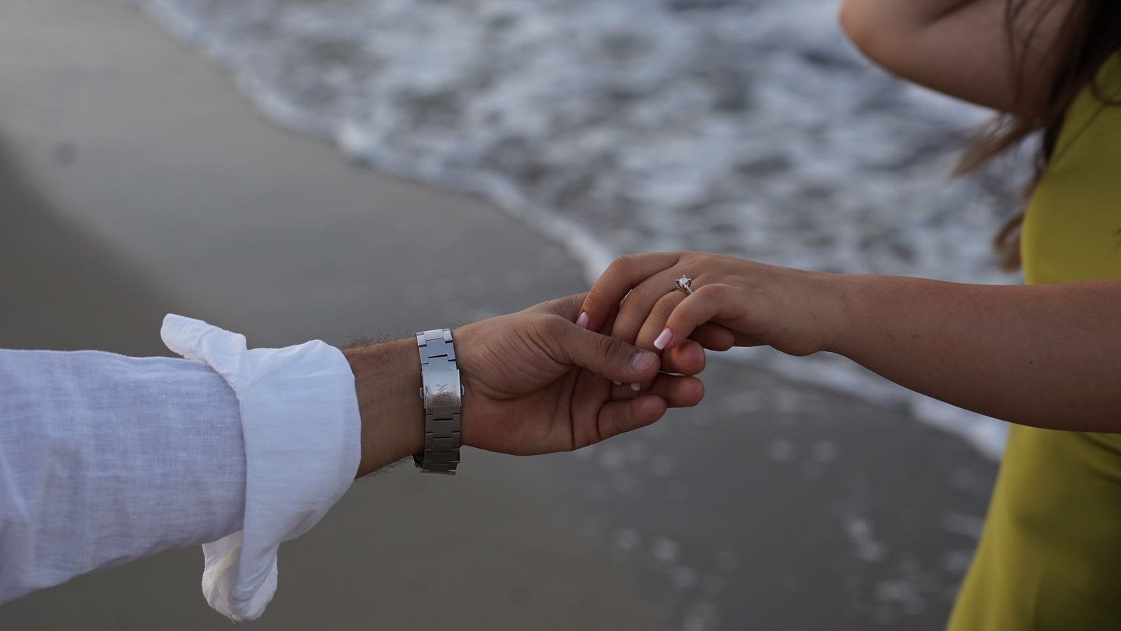 Bare hand on a beach towel after a woman lost her engagement ring in the lake weeks after the proposal