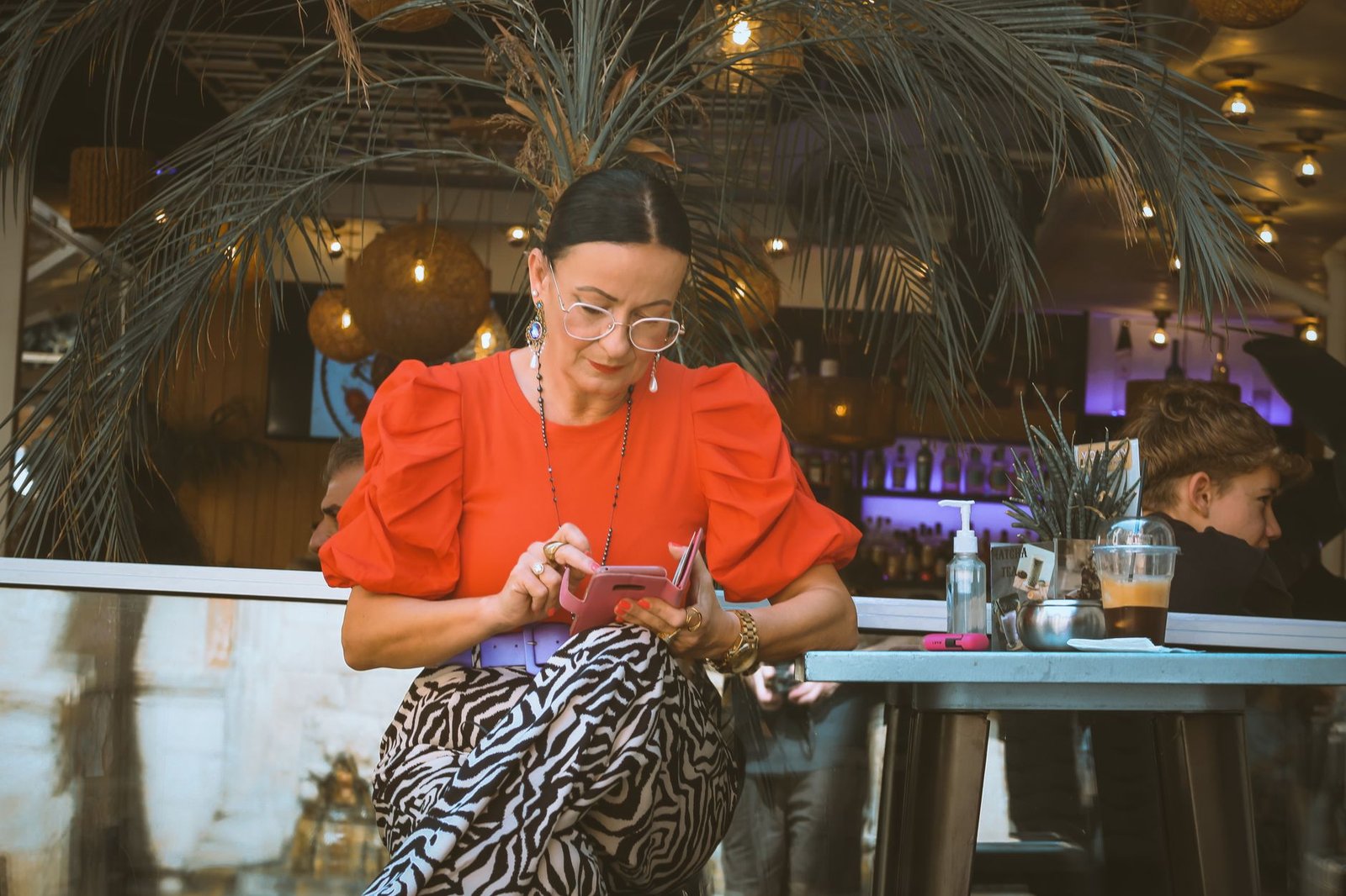 Woman texting a friend from a bar table during an awkward second date