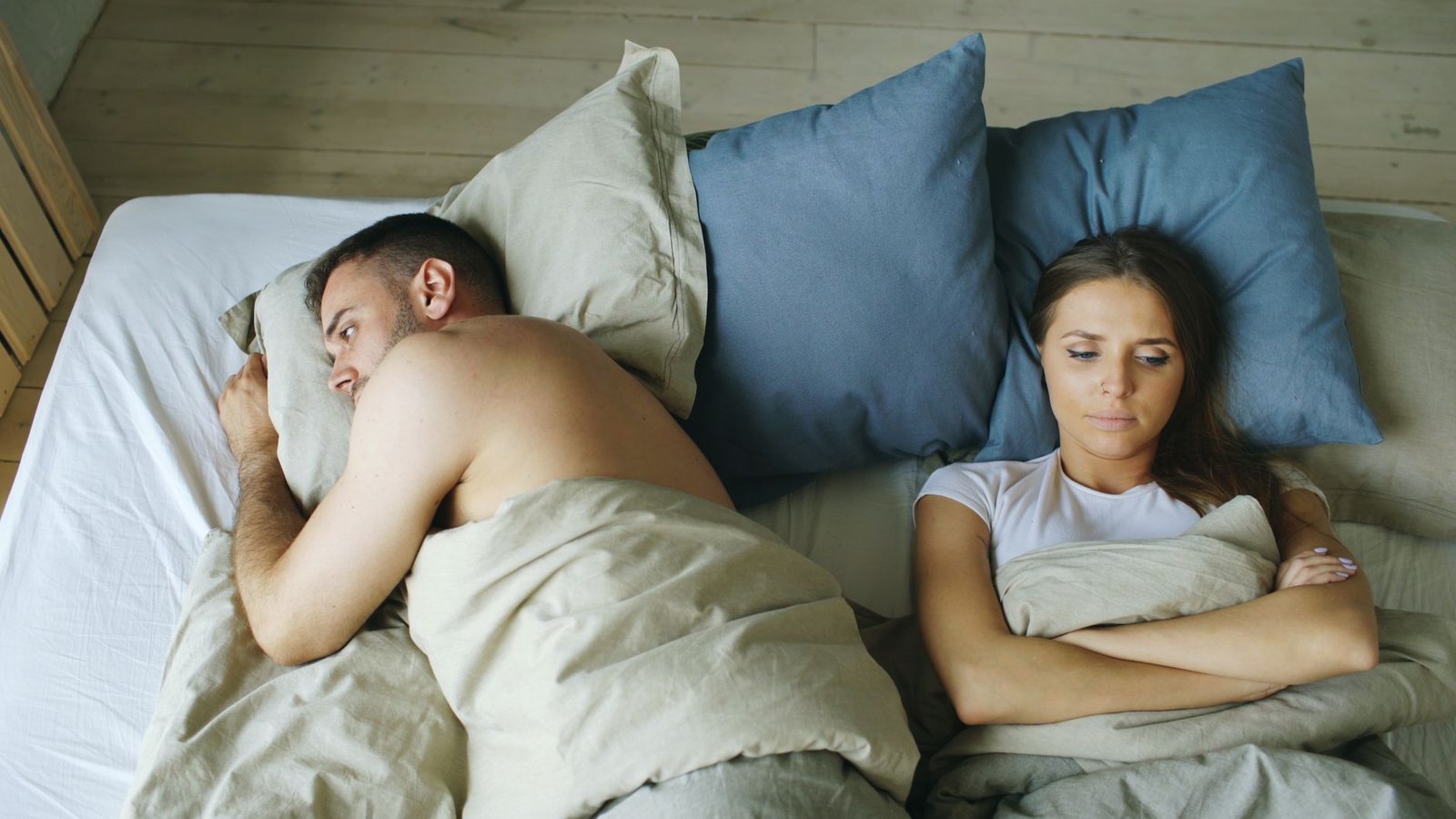 Couple sleeping under separate blankets because he runs hot and she is always cold