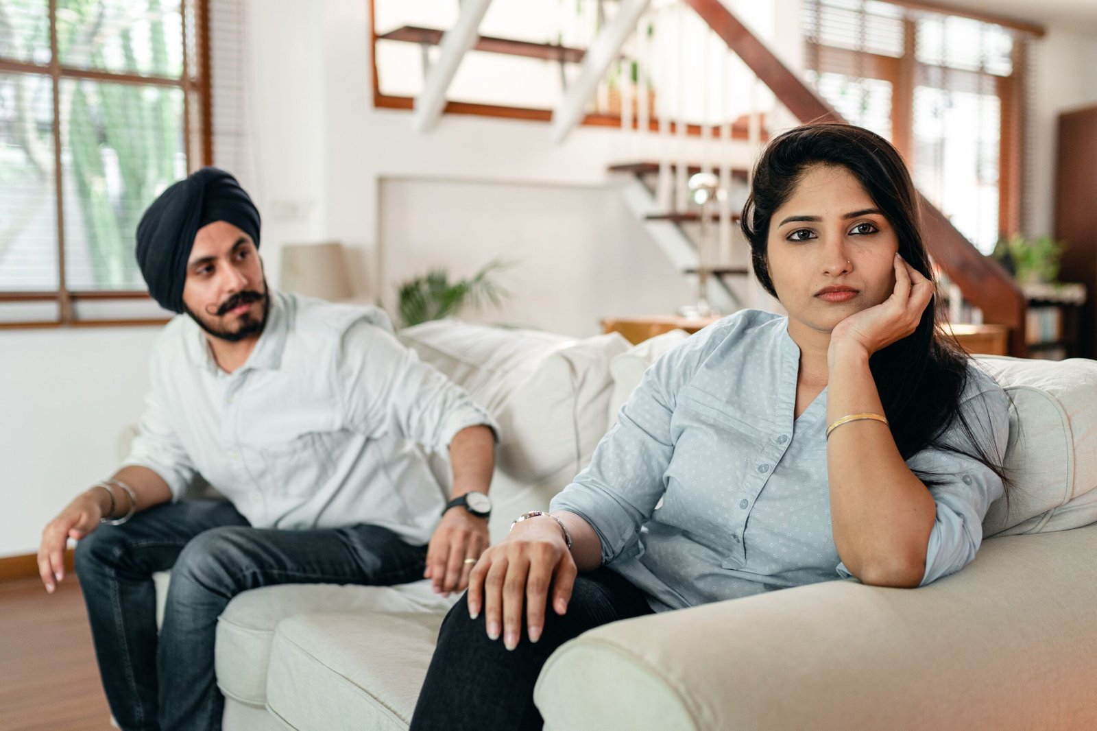 Couple sitting quietly on the couch after an argument, thinking it over