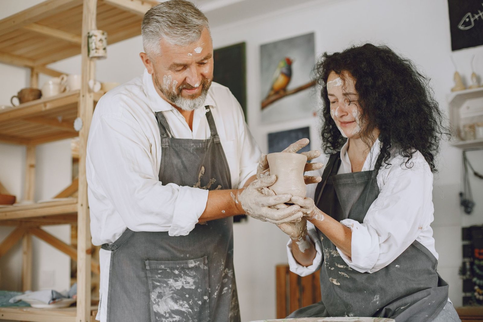 Couple laughing over lopsided bowls at a pottery class surprise night