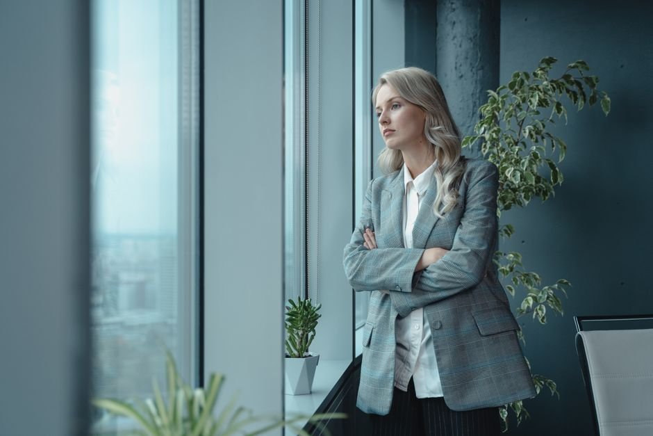 Woman riding alone in an elevator with a thoughtful expression