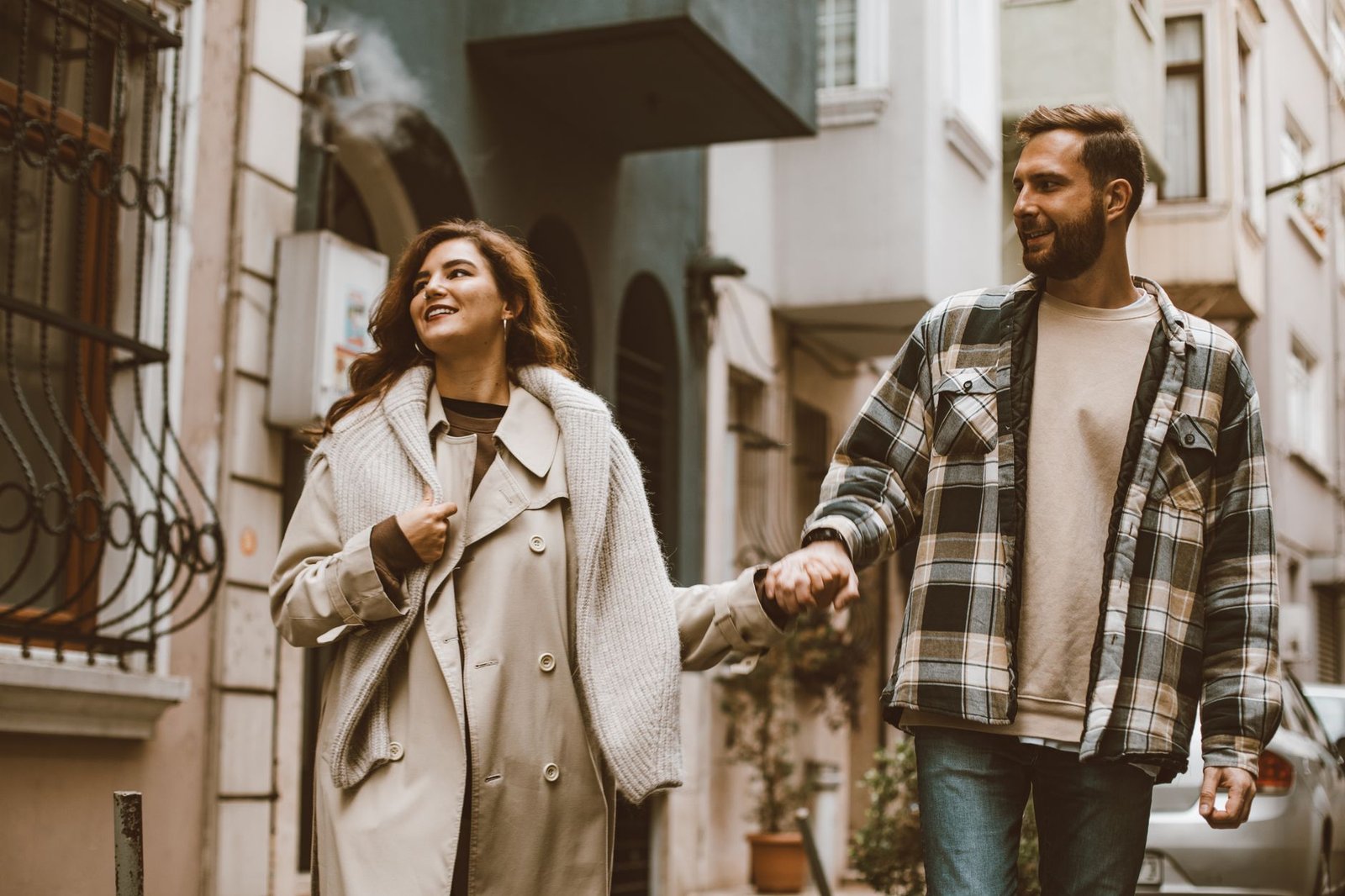 Couple walking hand in hand through a small town in fall