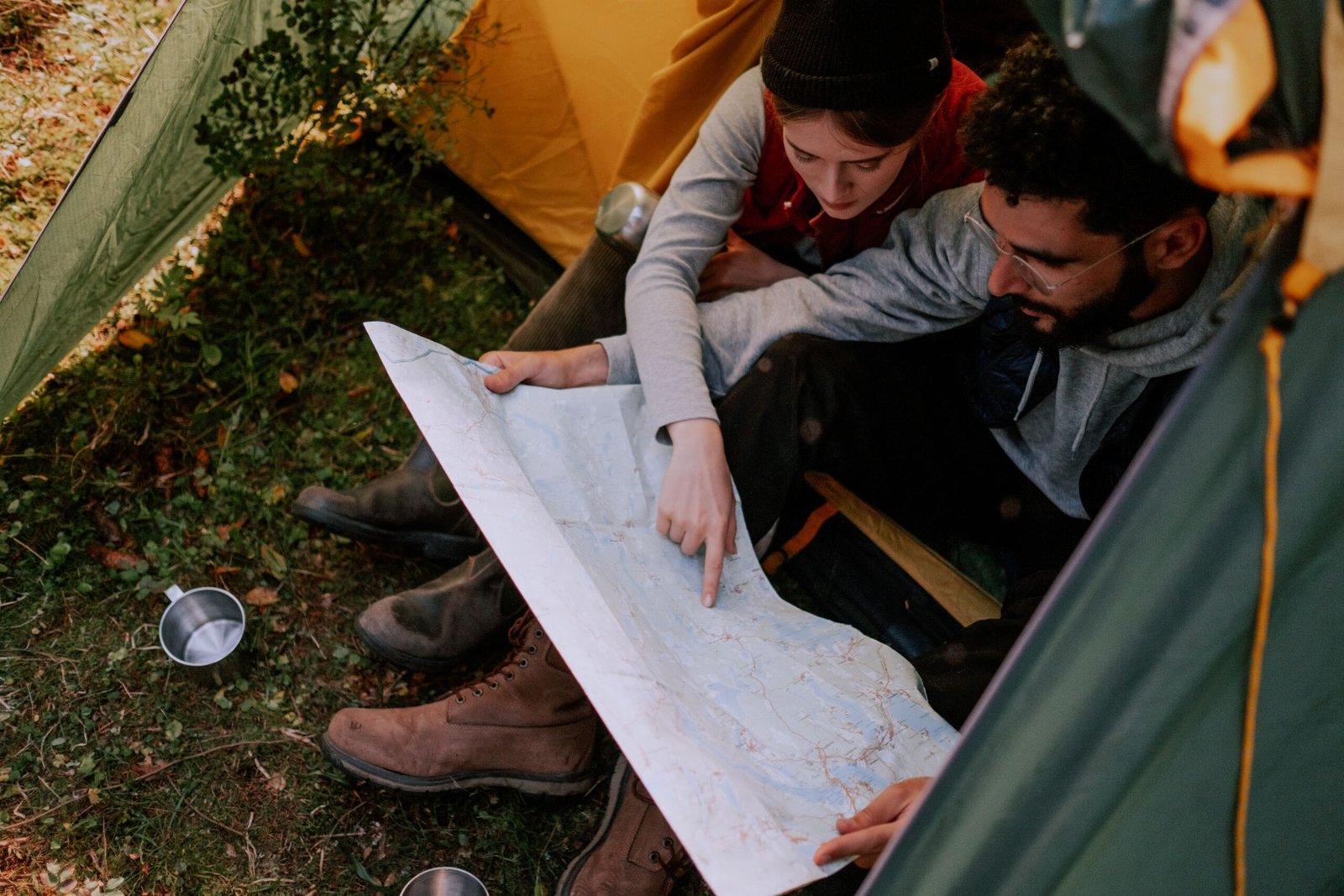 Couple inside a tent looking at a map planning their trip
