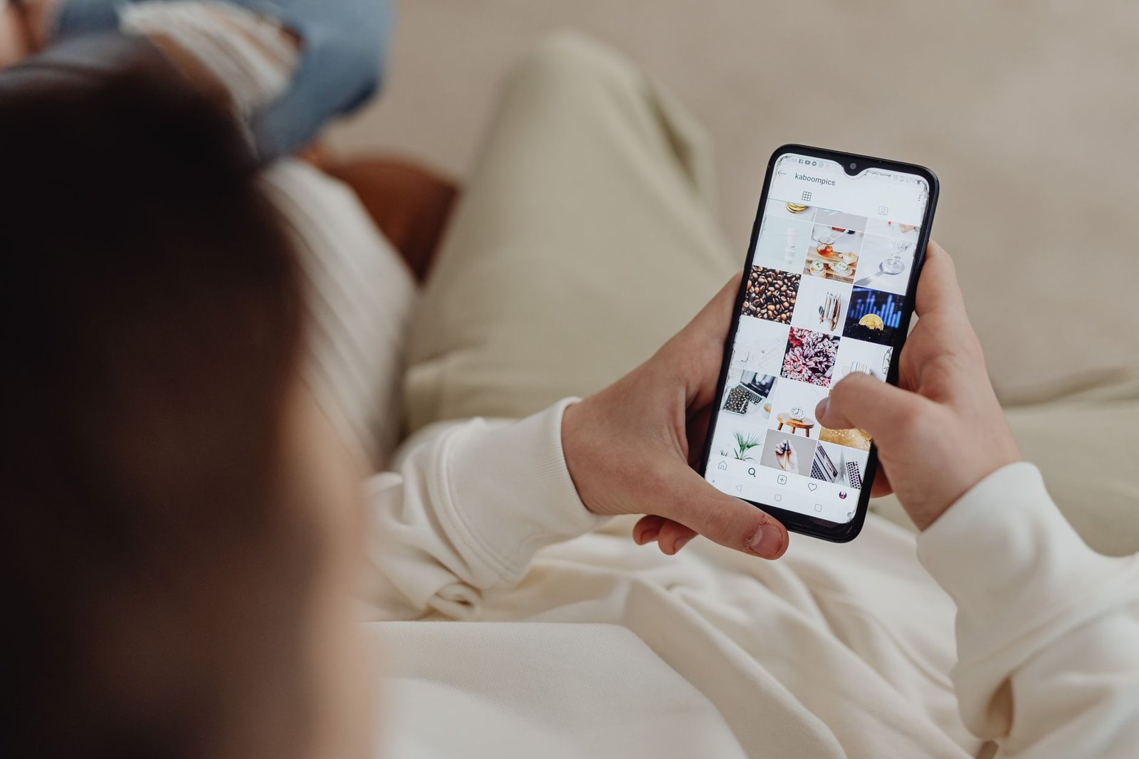 Woman scrolling old photos on her phone late at night